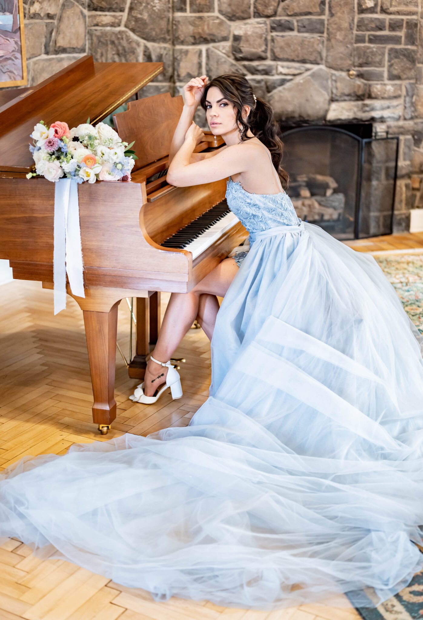Bridal portrait sitting at a piano at The Inn on Officer's Garden, Romantic bridal portrait in unique baby blue wedding dress, wild-flower themed bouquet with pastel colours