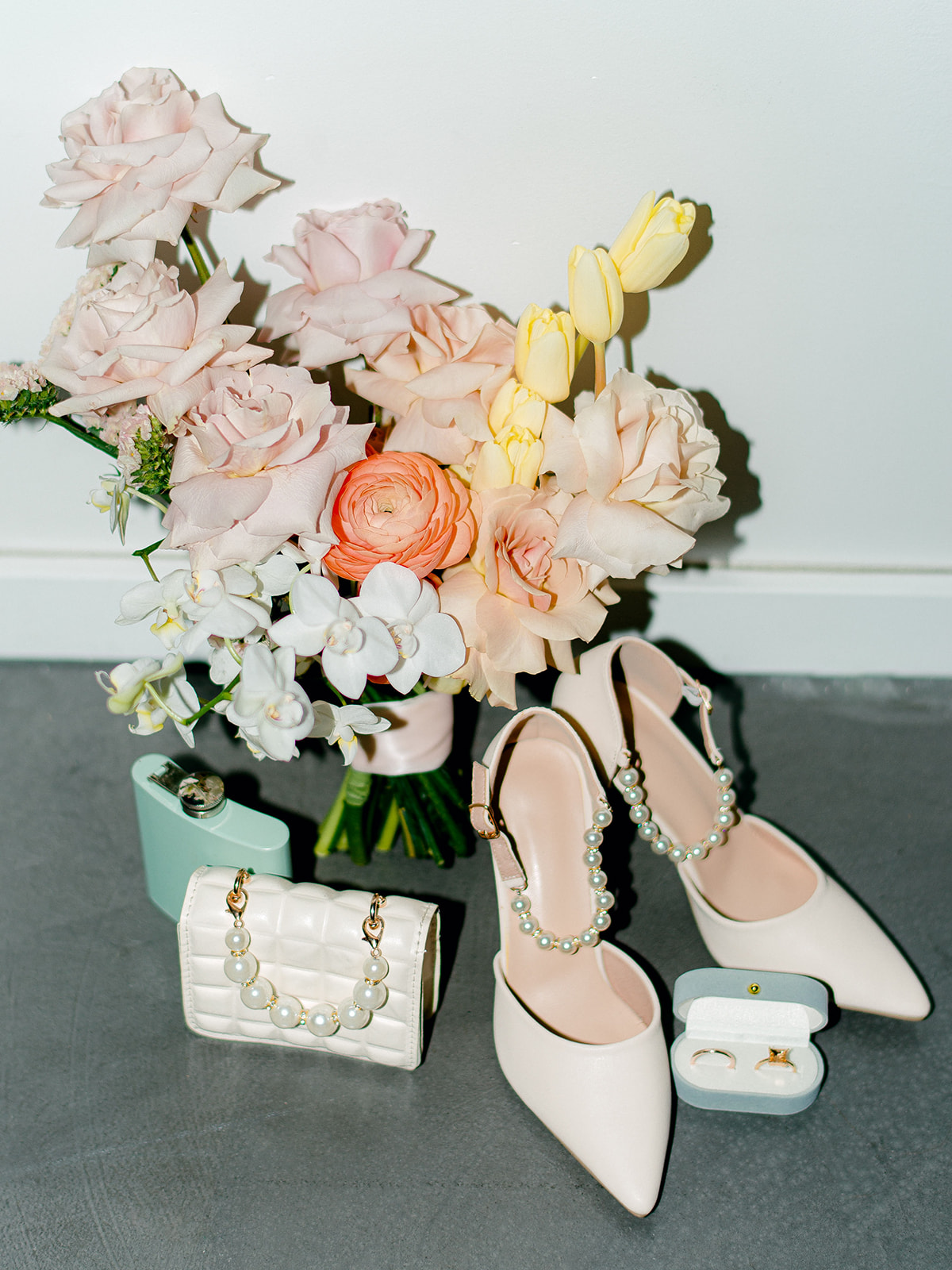 Colourful bridal bouquet captured in detailed photo alongside blue velvet ring box, tiffany blue flask and mini quilted bridal purse, studio wedding venue ideas, feminine bridal accessories
