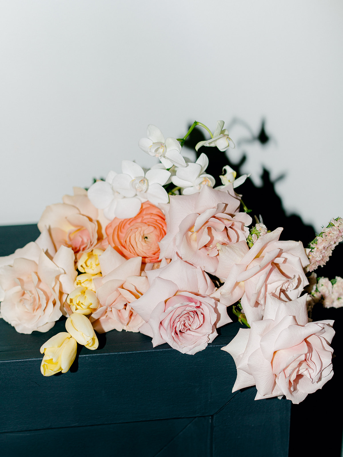 A feminine and romantic bouquet perfectly paired with modern and minimal studio aesthetics, creating an enchanting visual contrast, creating a captivating picture through the use of flash photography, showcasing the beauty and intricate details of the bride's bouquet