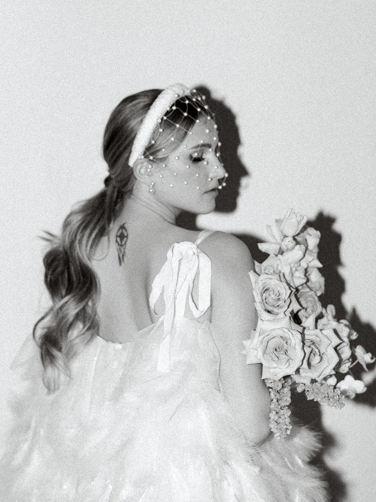 Elegant bridal portrait highlighting the charm of a modern birdcage veil and a beautifully adorned bridal headband, alternative veil ideas for the fashion-forward bride, black and white bridal portraits for a vintage and classic vibe