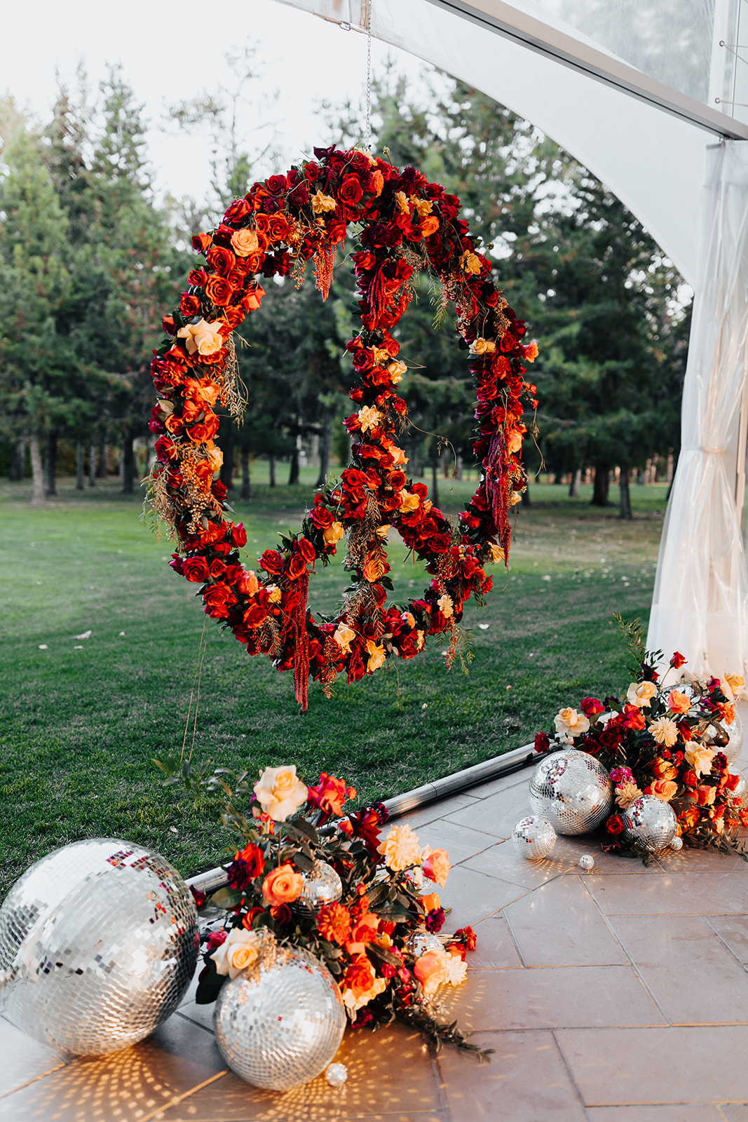 unique floral wedding installation, floral peace sign as ceremony backdrop with disco balls