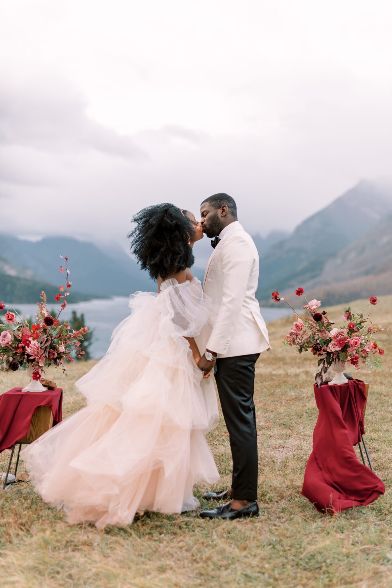 Intimate Elopement in Waterton Alberta, bride wearing blush wedding dress by Alexandra Victoria Rose, mountain lakeside couples portrait inspiration, fall floral inspiration in merlot and berry