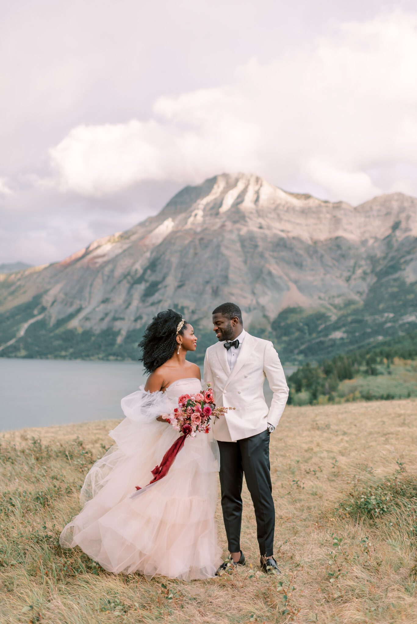 Intimate Elopement in Waterton Alberta, bride wearing blush wedding dress by Alexandra Victoria Rose, mountain lakeside portrait inspiration