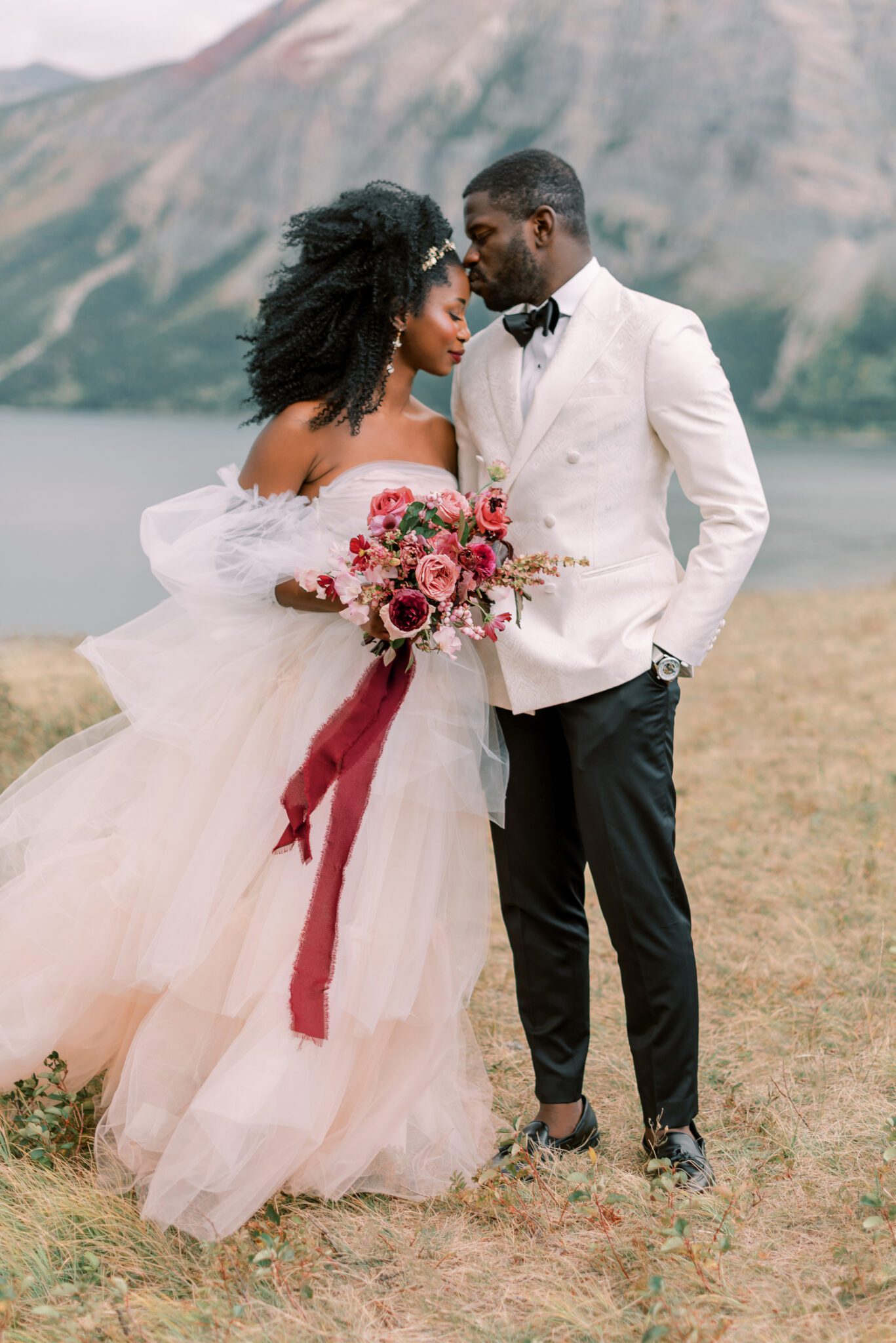couple portraits in mountain landscape in Waterton, Alberta, bridal bouquet by Alexandra Victoria Rose, fall elopement portraits