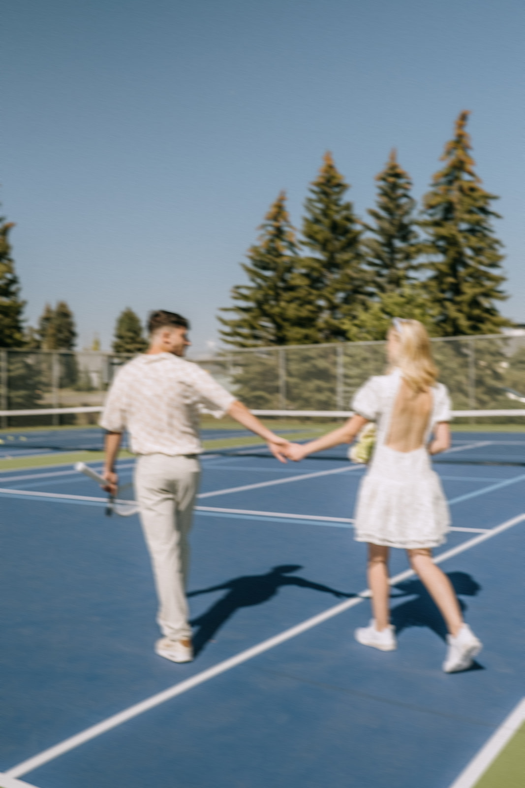 trendy blurred photography for outdoor couple's portraits, Tennis themed wedding ideas for the modern runaway bride, open-back short wedding dress worn with sneakers for a sporty bride