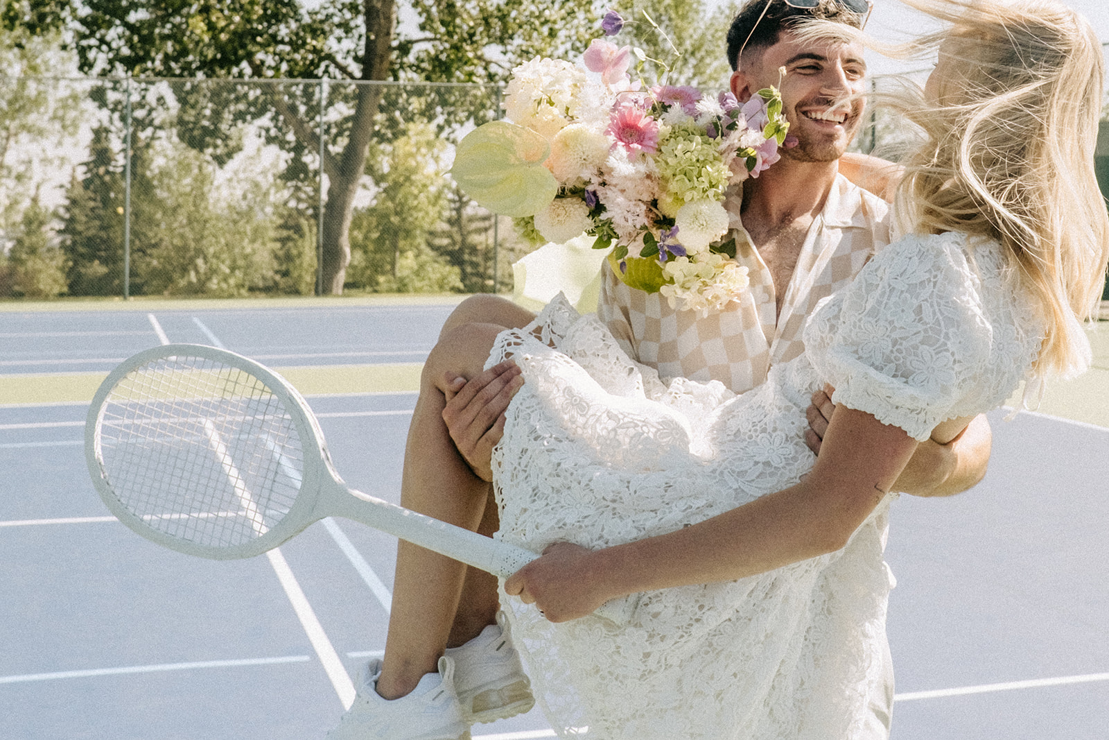 Modern runaway bride sporting short wedding dress for a unique wedding look, tennis-themed wedding ideas for a sporty bridal inspiration, pink and chartreuse bouquet ideas