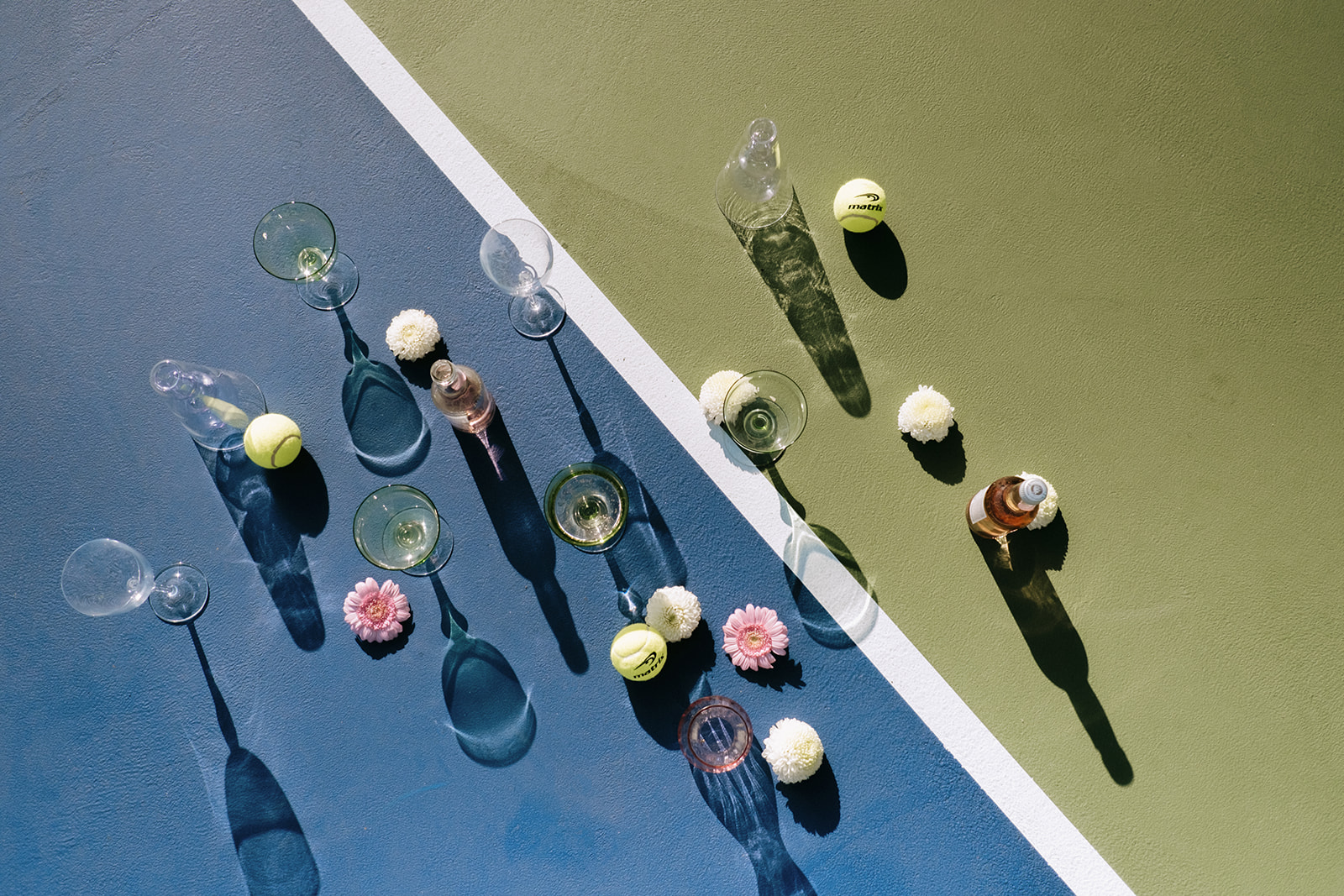Unique tennis-themed wedding inspiration, chartreuse coup and pastel pink glassware featured in alternative flat lay photo, summery florals in pastel pink and white for wedding details photo, neon and pastel colour palette ideas for summer wedding
