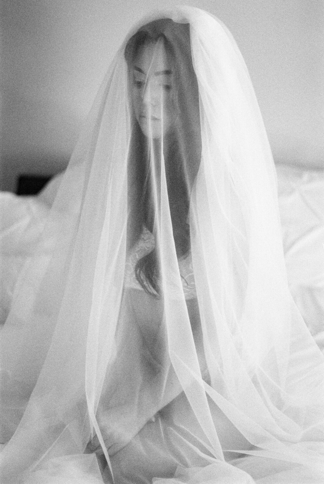 Creative black and white bridal boudoir photo featuring film photography, Bride poses with veil for intimate bridal photoshoot