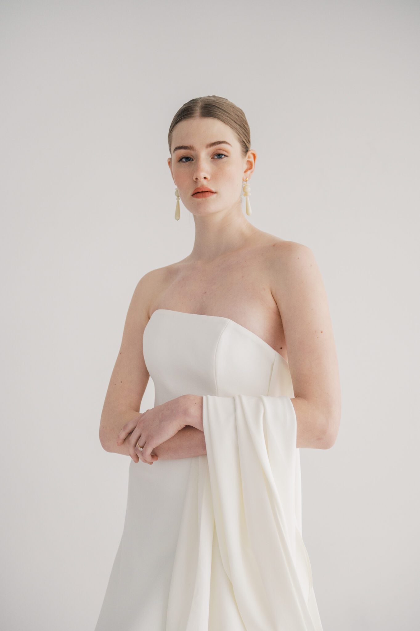 Fashion-forward bridal attire for a chic wedding, sophisticated and minimalist makeup by Amplified Artistry in neutral tones for a modern wedding aesthetic