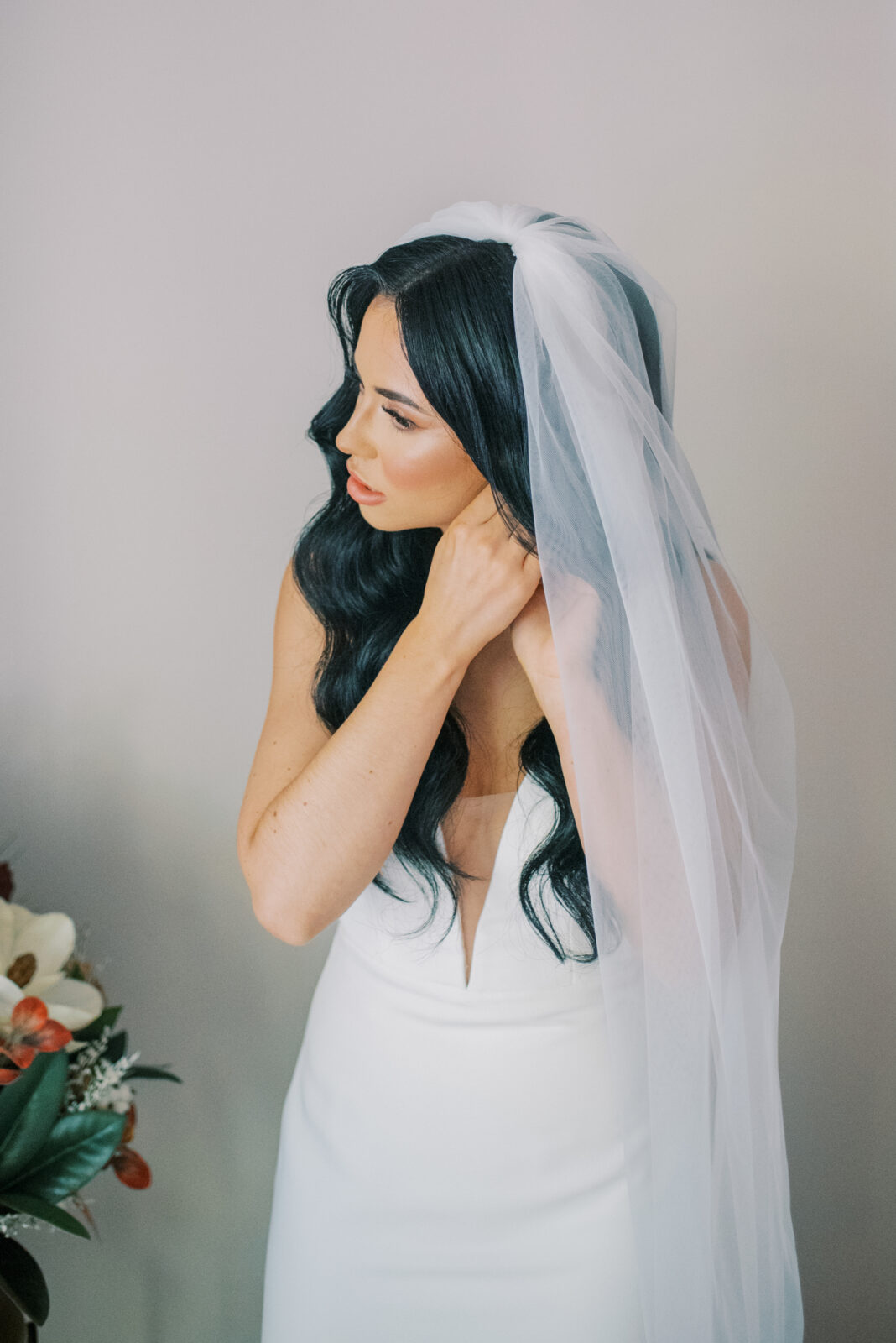chic bride getting ready photos, wearing veil and putting in earrings, long loose curls bridal hairstyle with veil and middle part