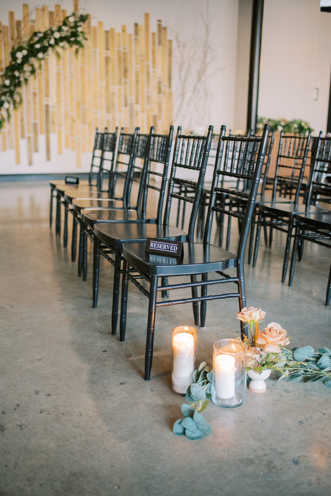 black chiavari guest chairs for modern and classic ceremony style, reserved sign inspiration for ceremony, industrial wedding venue with concrete floor 