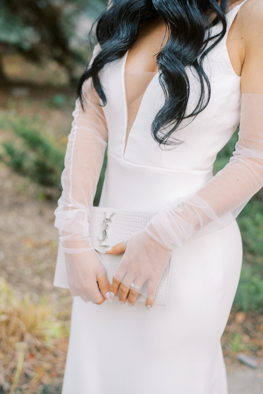 Modern bridal fashion: Showcasing the latest trends and styles for brides, white bridal clutch style, simple and modern wedding gown from Delica Bridal styled with sheer bridal gloves 