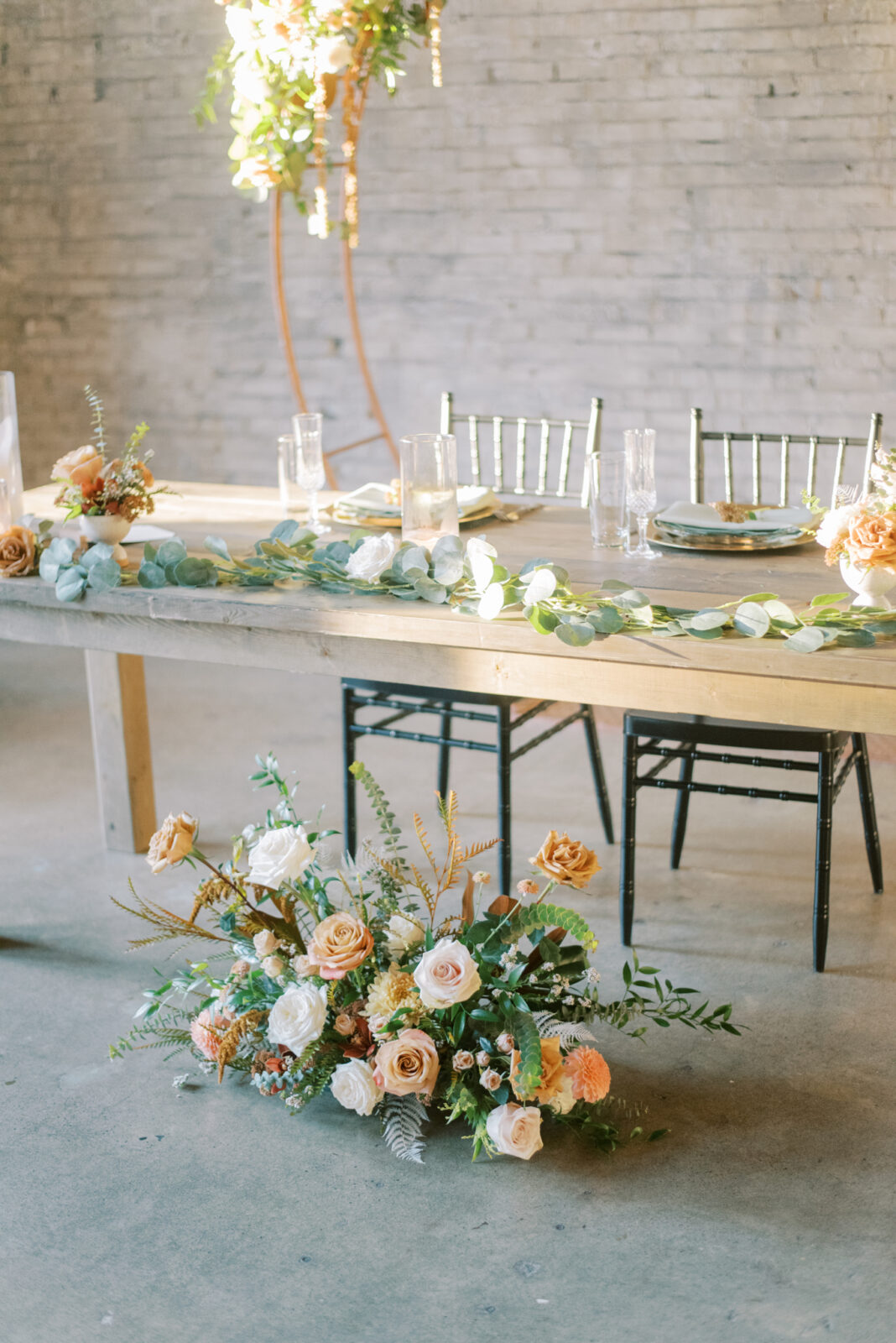 Fall wedding colour scheme that creates a harmonious blend of autumnal hues, industrial reception venue featuring brick wall and concrete floors, detailed photos of reception during sunset
