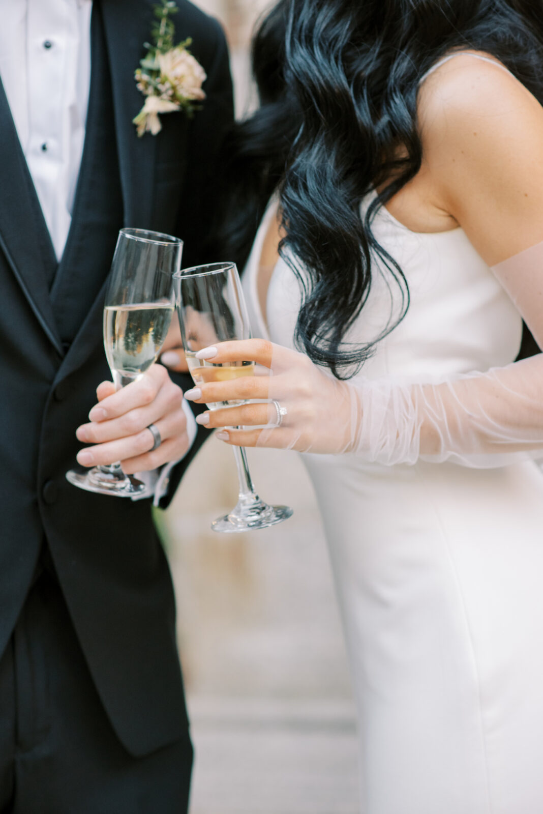 Bride and groom clinking champagne glasses, modern bride and groom portraits, chic sheer bridal gloves