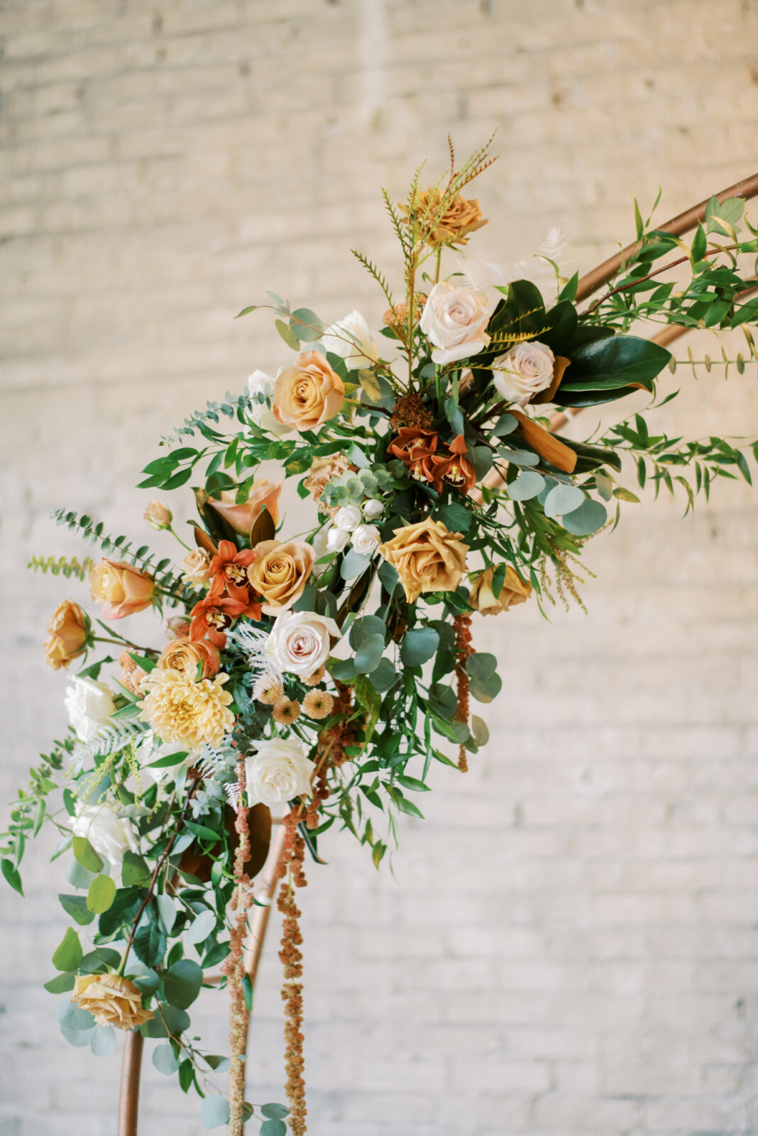 gold circular arch with fall-toned florals and greenery at the end of the aisle, circular arch shape inspiration, October wedding colours in autumn hues