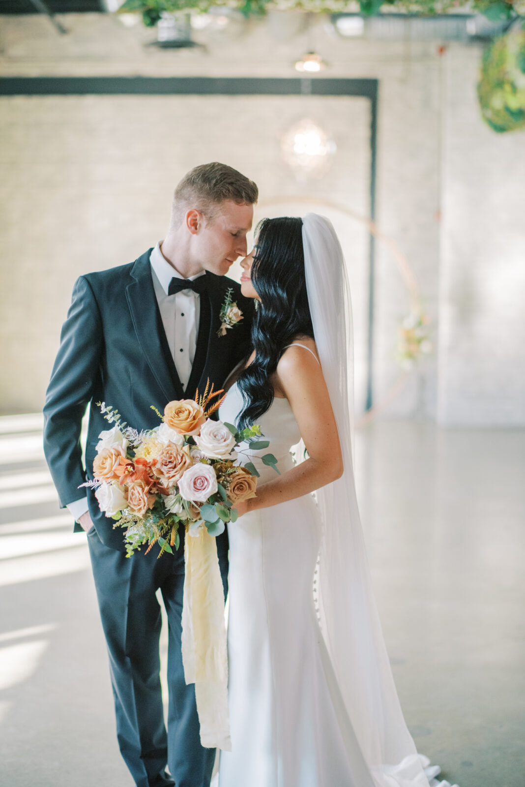 bride and groom in modern wedding day attire for fall wedding, romantic couples portrait ideas, October wedding colour scheme for bouquet featuring long bouquet tie 
