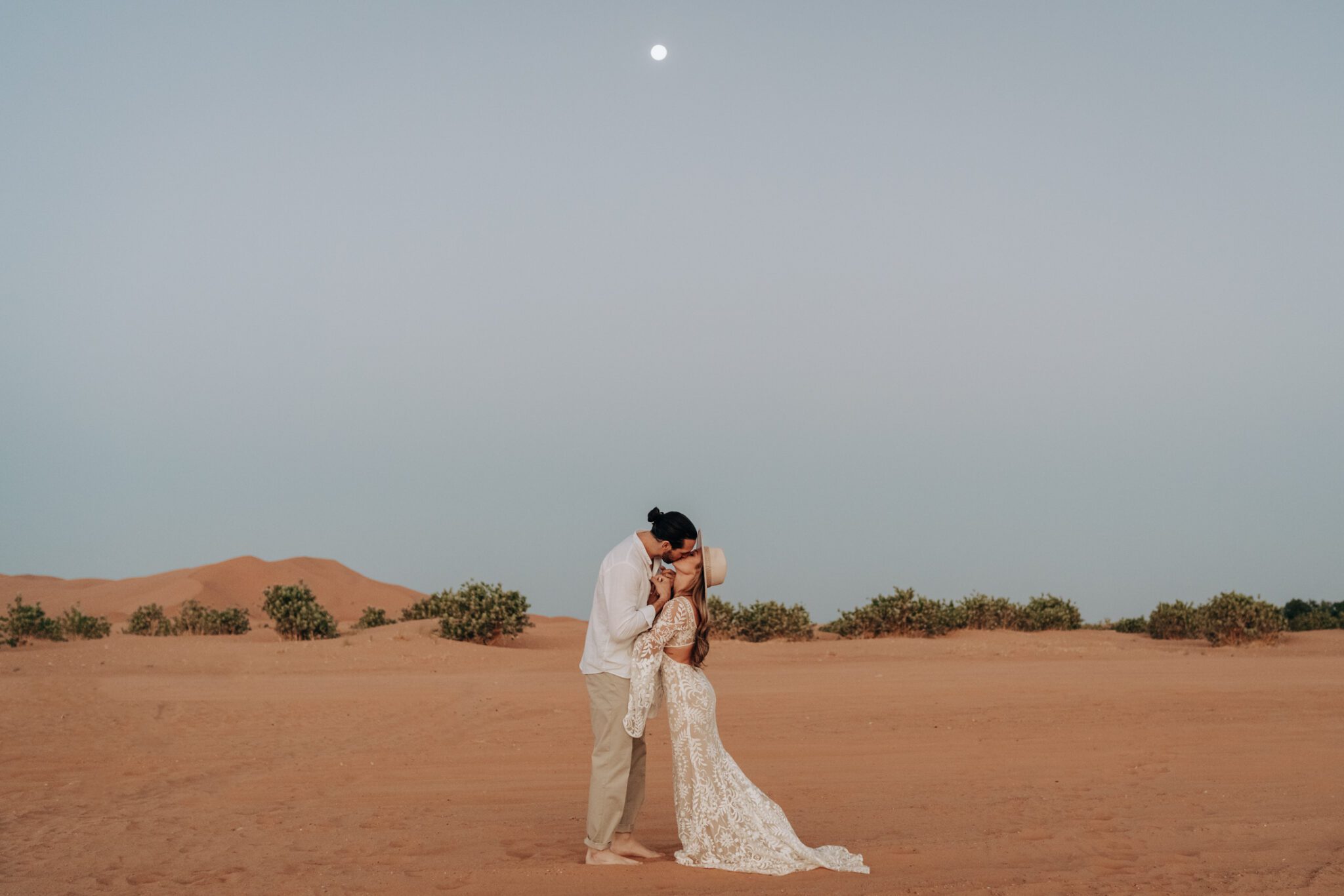 Couple kissing in the Sahara Desert during their moroccan inspired engagement session.