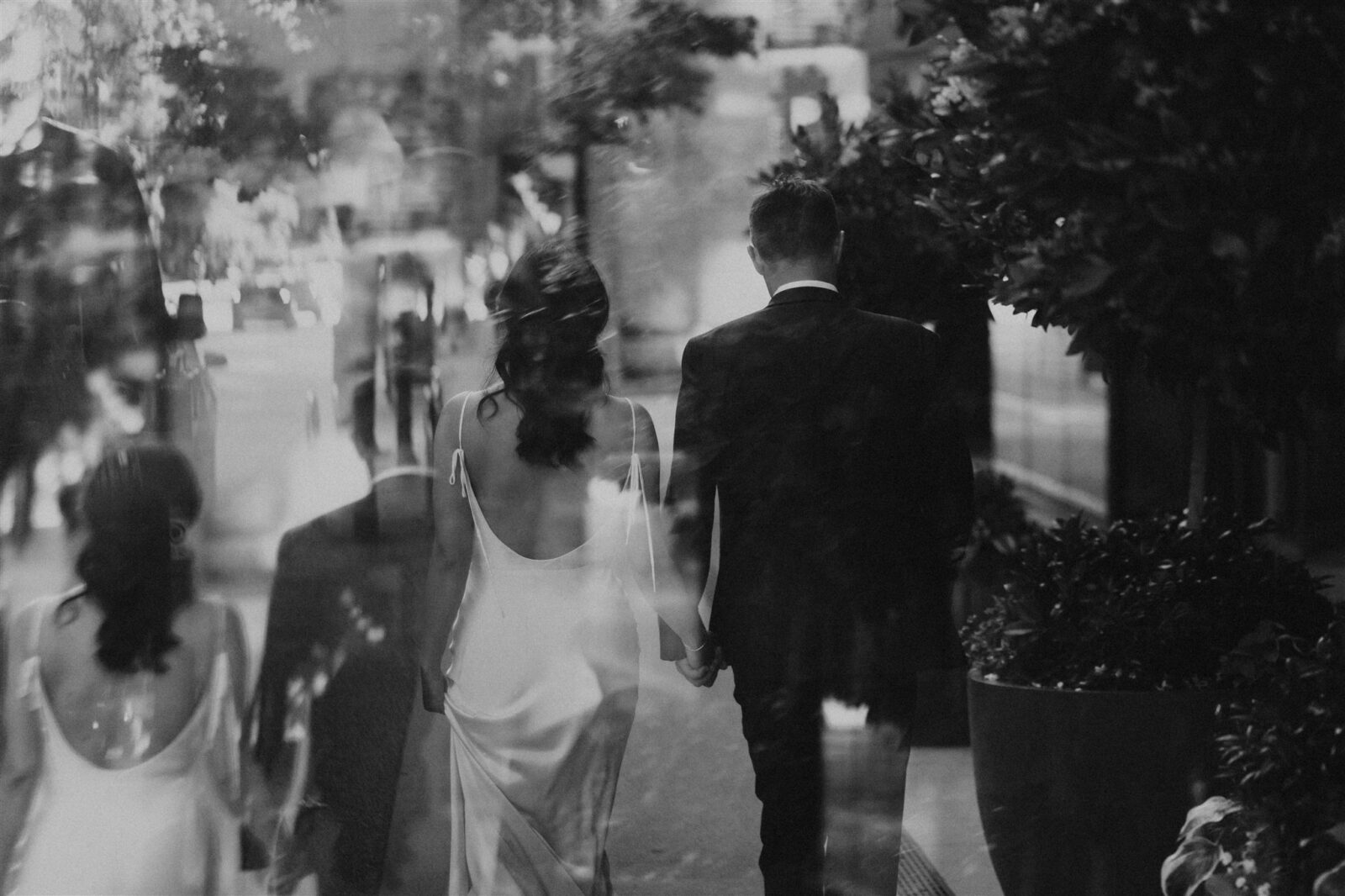 Black and white double exposure image of couple walking. Downtown Vancouver wedding photograpy by Abigail Eveline Photography.