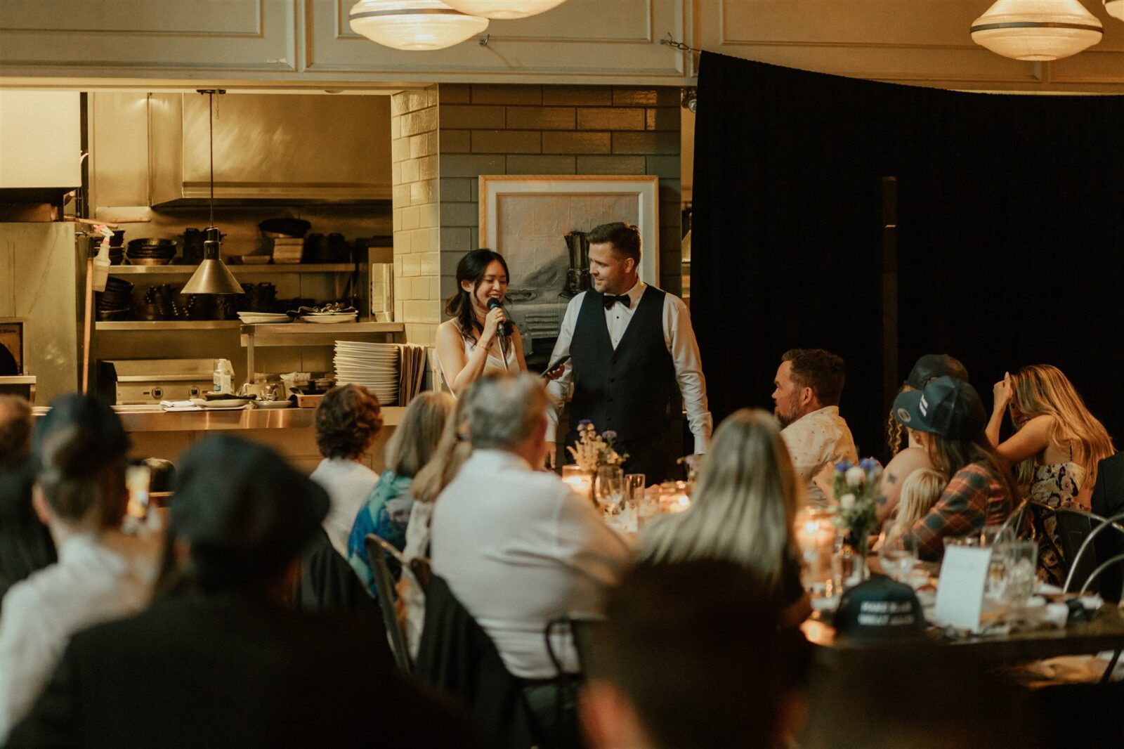 Couple stands for speech during intimate wedding reception dinner at Cafe Medina in Vancouver, captured by Abigail Eveline Photography.