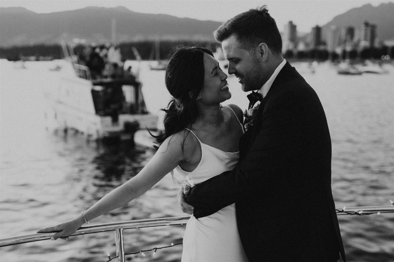 Bride and groom embrace on boat during Vancouver's Festival of Lights.