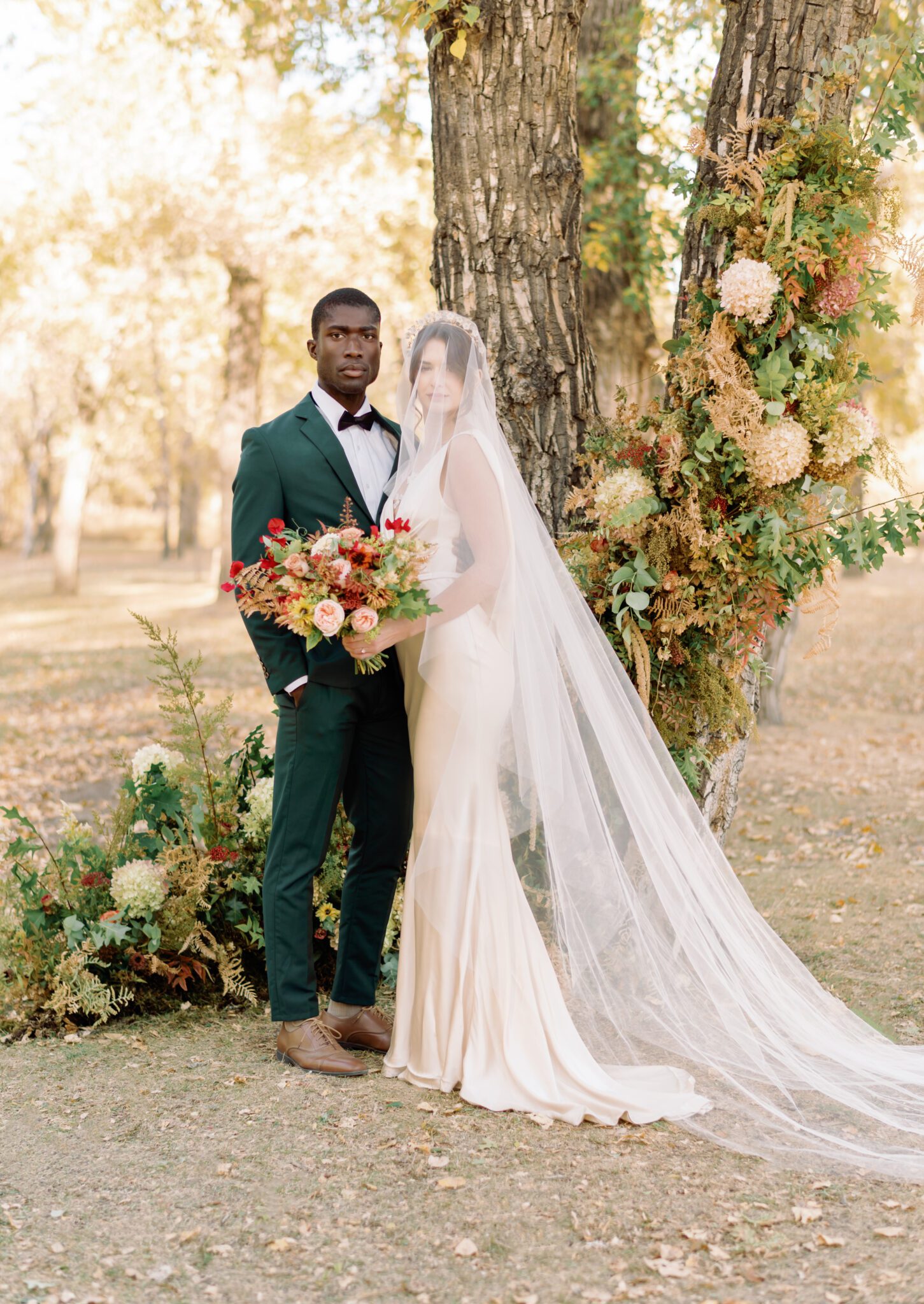 Fine art wedding photography by Kaity Body. Fall inspired wedding featuring emerald green suit and satin bridal gown with lace detail. Long elegant veil from Lovenote Bride. 