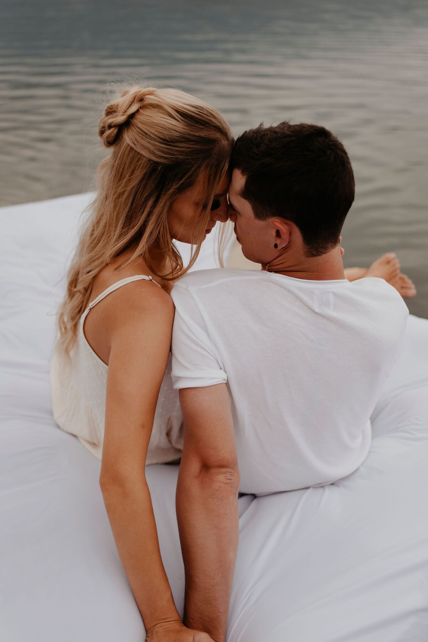 Couple sitting on a floating mattress, engagement session inspiration.