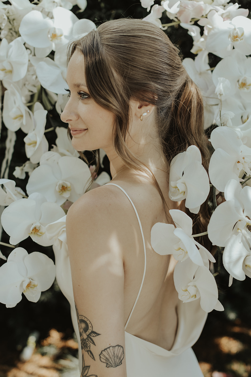 Bride surrounded by stunning white orchid bouquets by The Flower Library.
