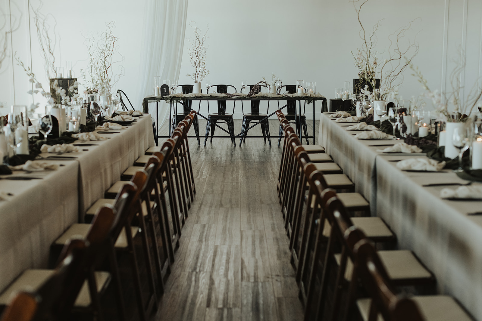 Moody and modern wedding reception at The Wallace in North Vancouver. Decorated with draped tapestry, and earthy, organic florals by The Flower Library.