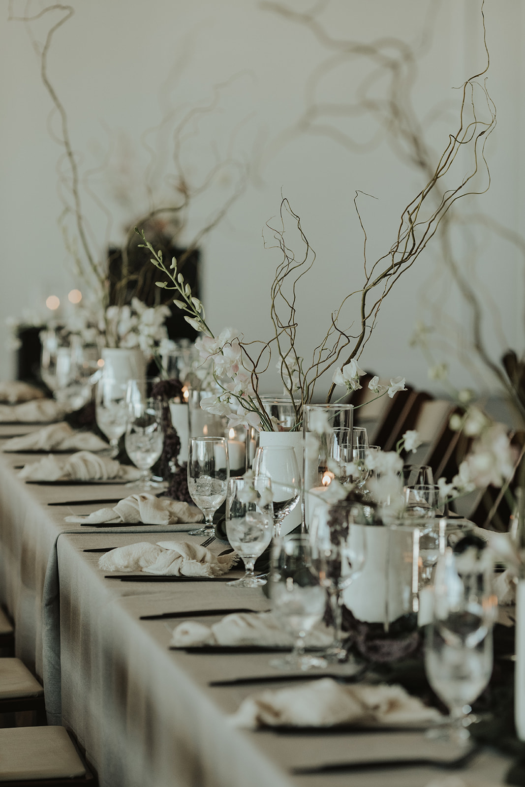 Moody and contemporary wedding reception at The Wallace in North Vancouver. Decorated with draped tapestry, and earthy, organic florals by The Flower Library.