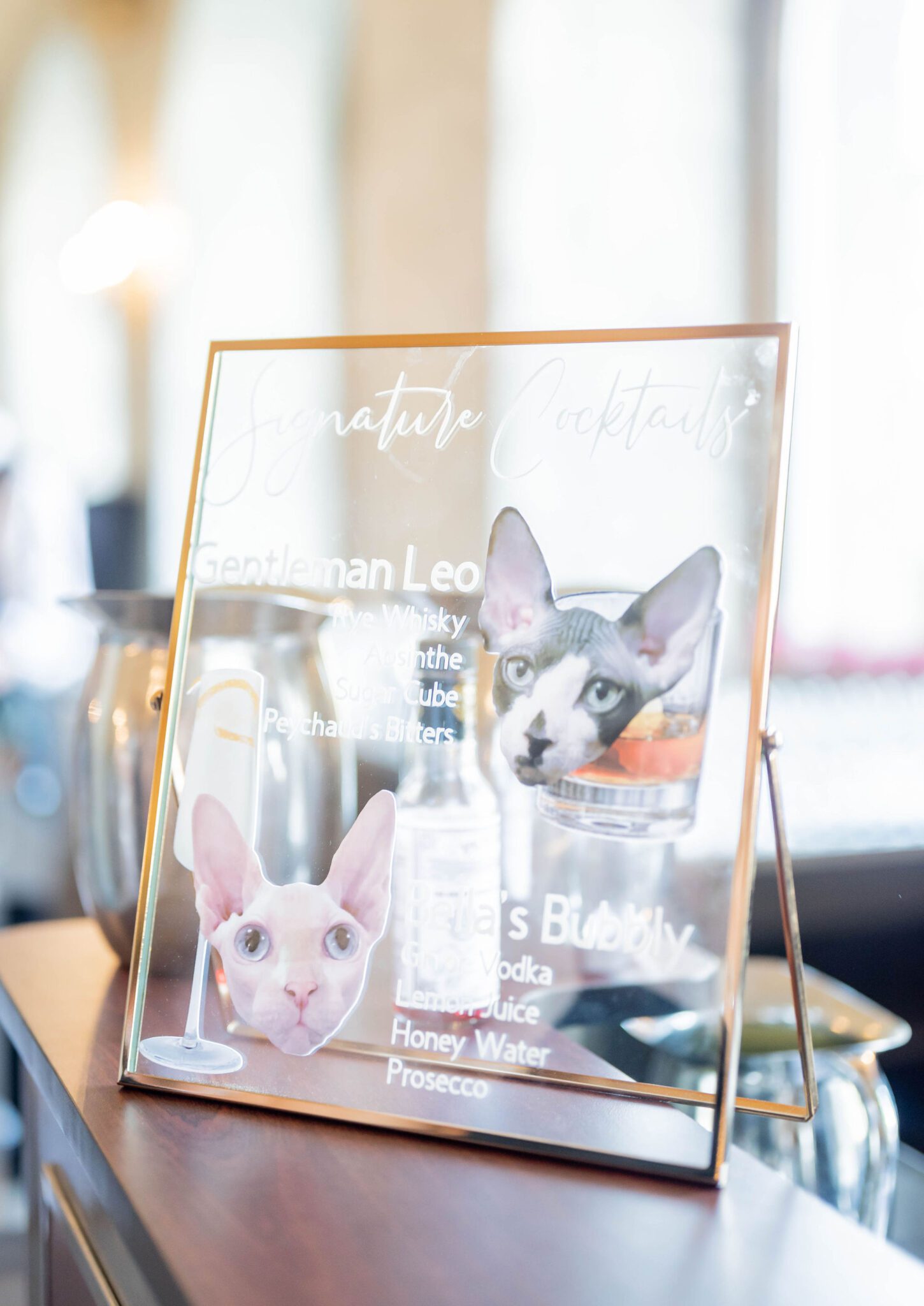 Custom hand-painted signage for signature cocktails representing the couple's cats at Banff Summer Wedding. 