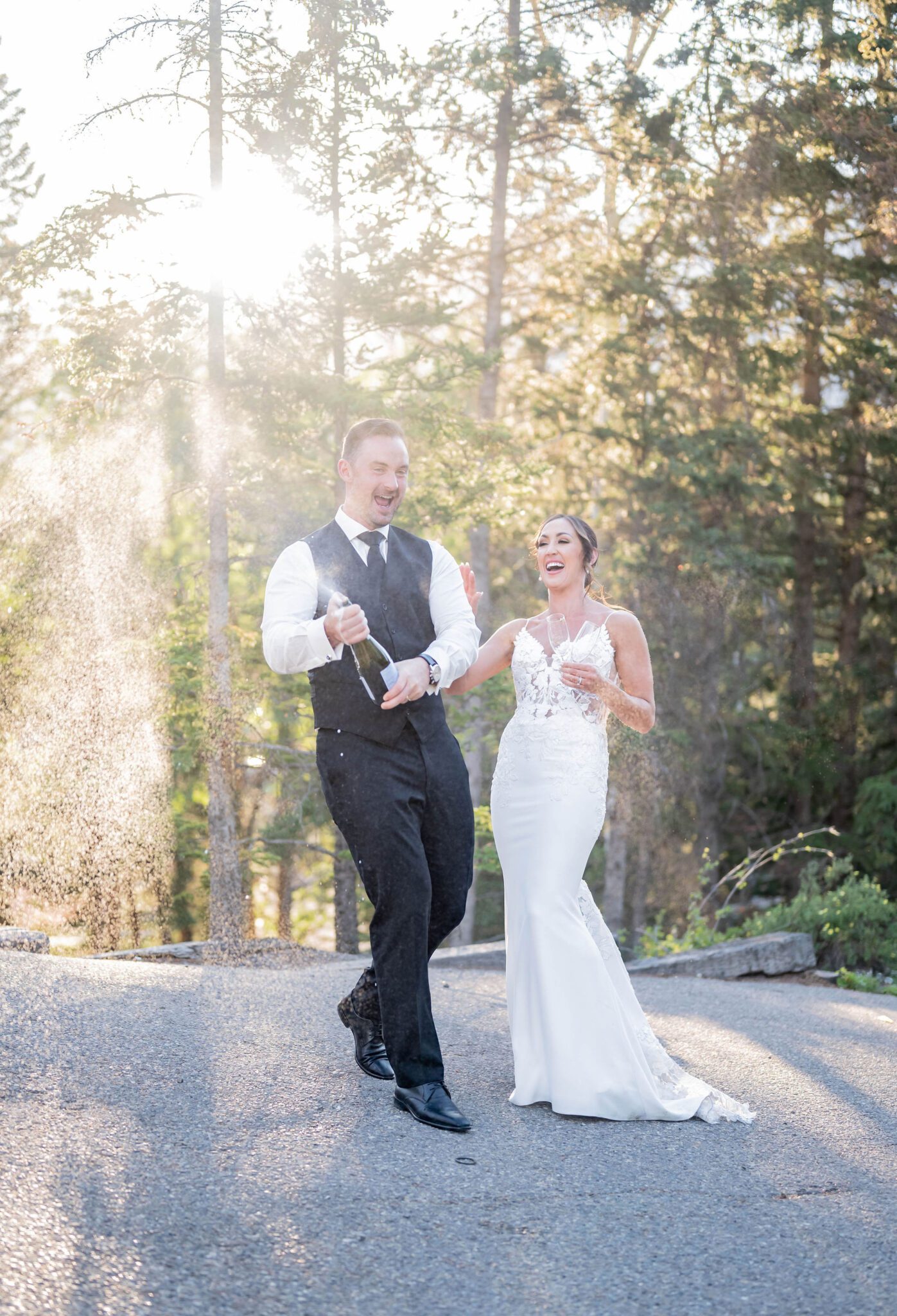 Bride and groom spraying champagne at their Banff Summer wedding, mountain wedding inspiration. 