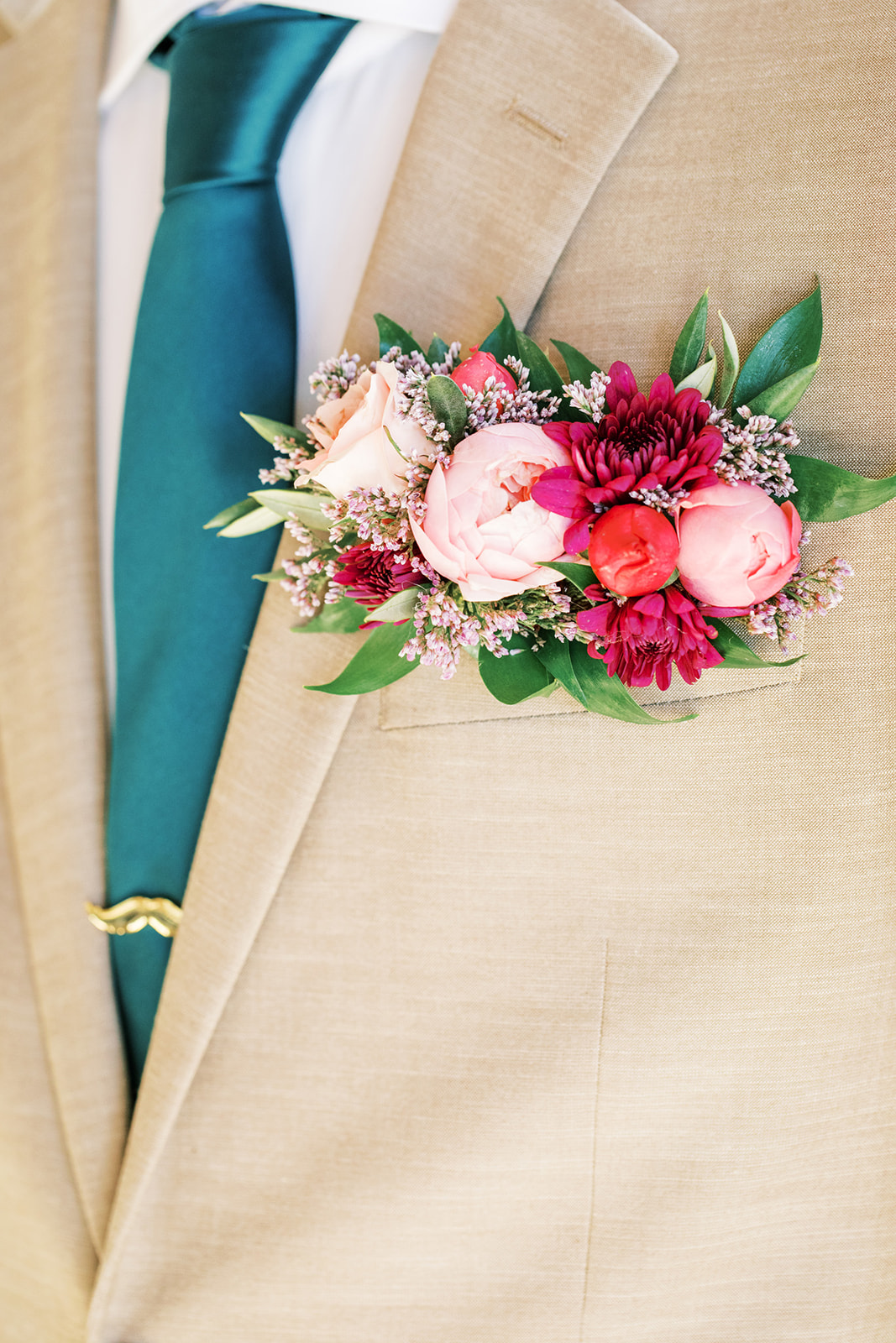 Colourful, wild pocket florals (boutenniere alternative) for the groom.  boutonniere by Rose & Vine, and brown groom suit with blue tie by Trinos Menswear.