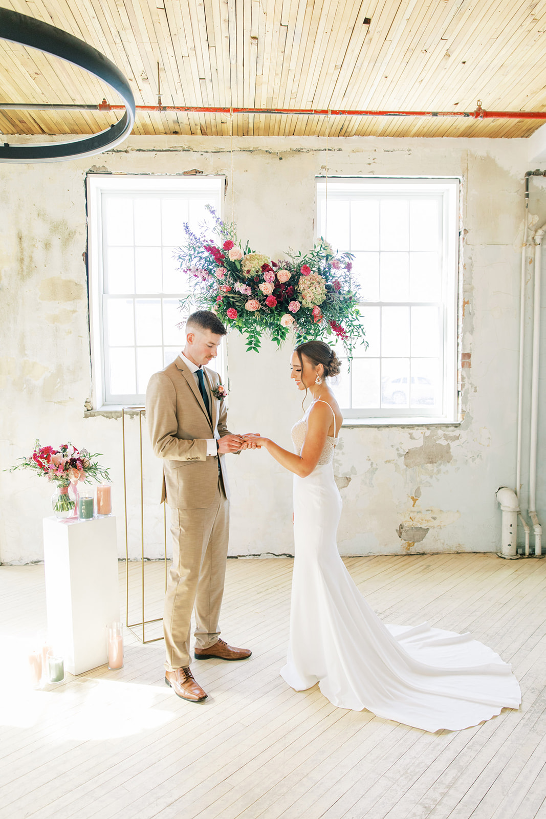 Couple during romantic, vintage inspired wedding ceremony, featuring hanging florals created by Rose & Vine.