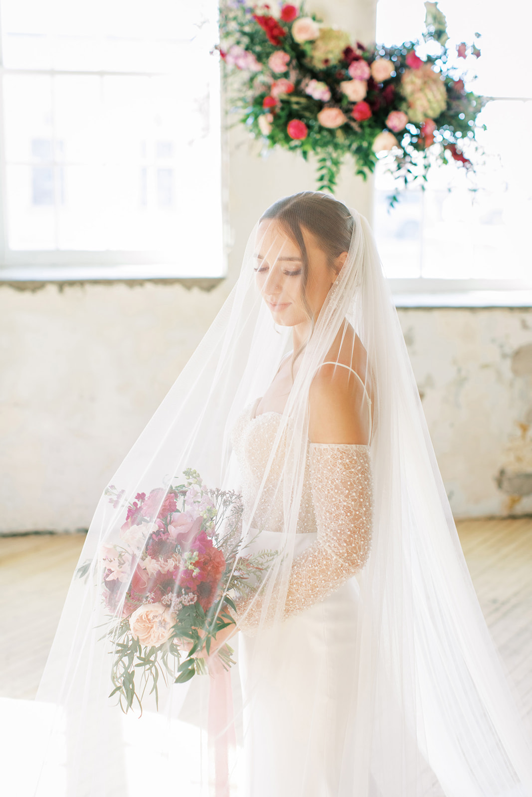 Stunning bridal portrait inspiration, bride wearing cathedral blusher veil during vintage inspired wedding ceremony, featuring hanging florals created by Rose & Vine. 
