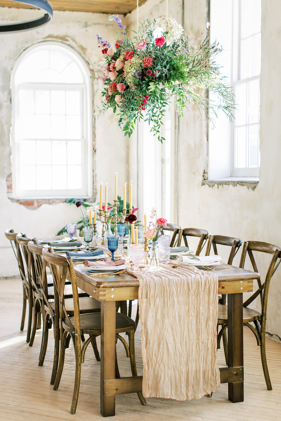 Playful colour palette, romantically styled wedding reception inspiration at Local Market YQR. Featuring hanging florals by Rose & Vine, vintage candelabras, and royal blue glassware. 