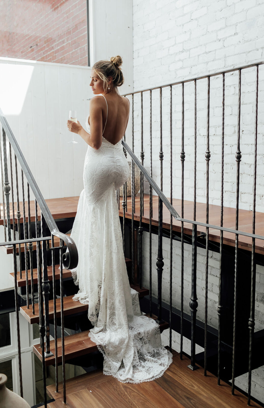 Brides wearing silhouette hugging ivory lace gown, with rose stretch lace, eyelash detailing, and stunning low back, Clo gown designed by Grace Loves Lace.