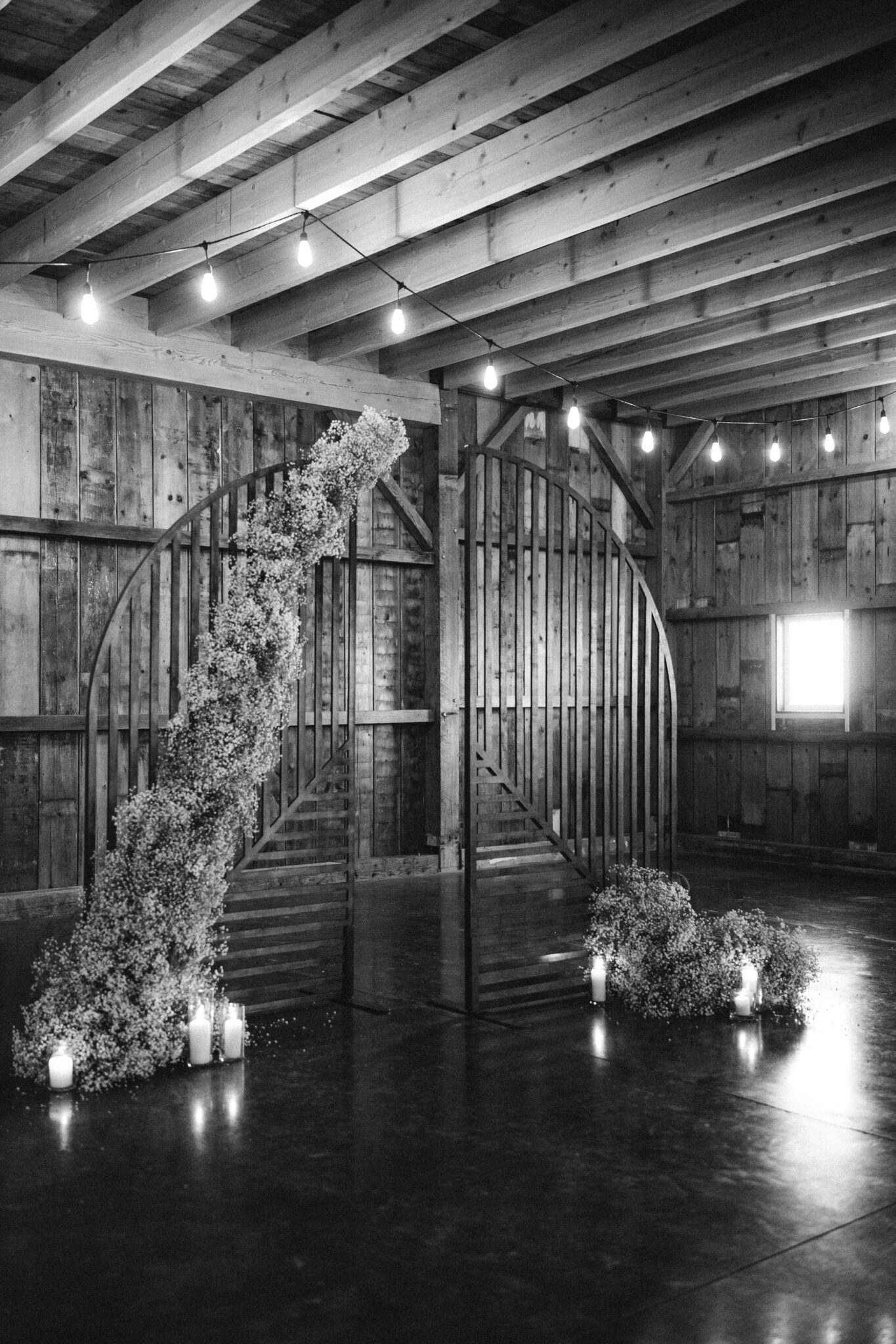 Modern whimsical baby's breath installation for the ceremony arch at this Country Chic wedding, paired with romantic candlelight for a warm cozy winter wedding ceremony.