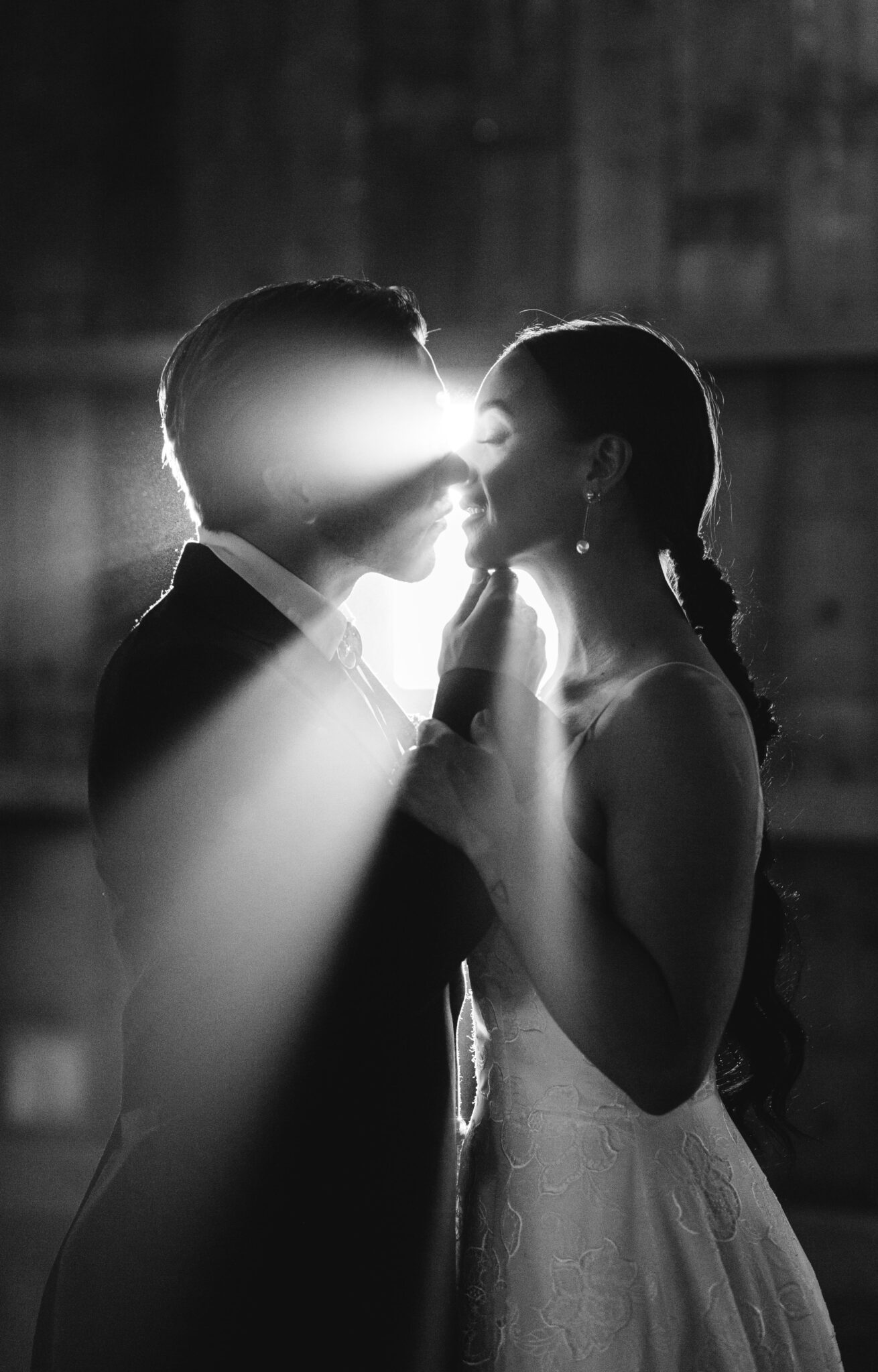 Vintage meets Contemporary Wedding Inspiration: black and white photography of bride and groom first kiss with light shining through, creative kiss photograph, creative professional wedding photography, bride and groom wedding portrait