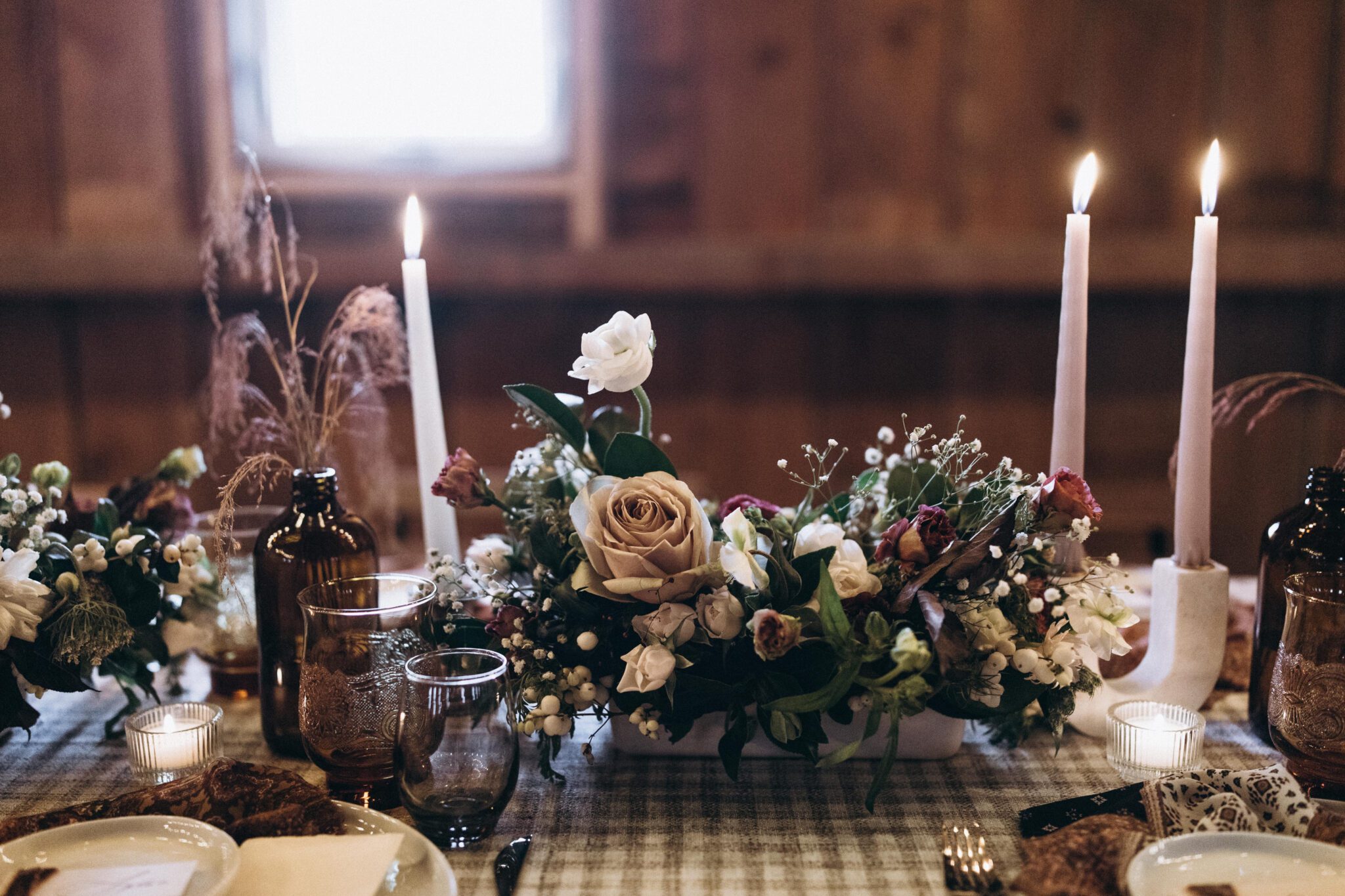 Country chic tablescape design with earthy florals, taper candles, textured and patterned linens, in Countryside Barn in Lethbridge, Alberta. 