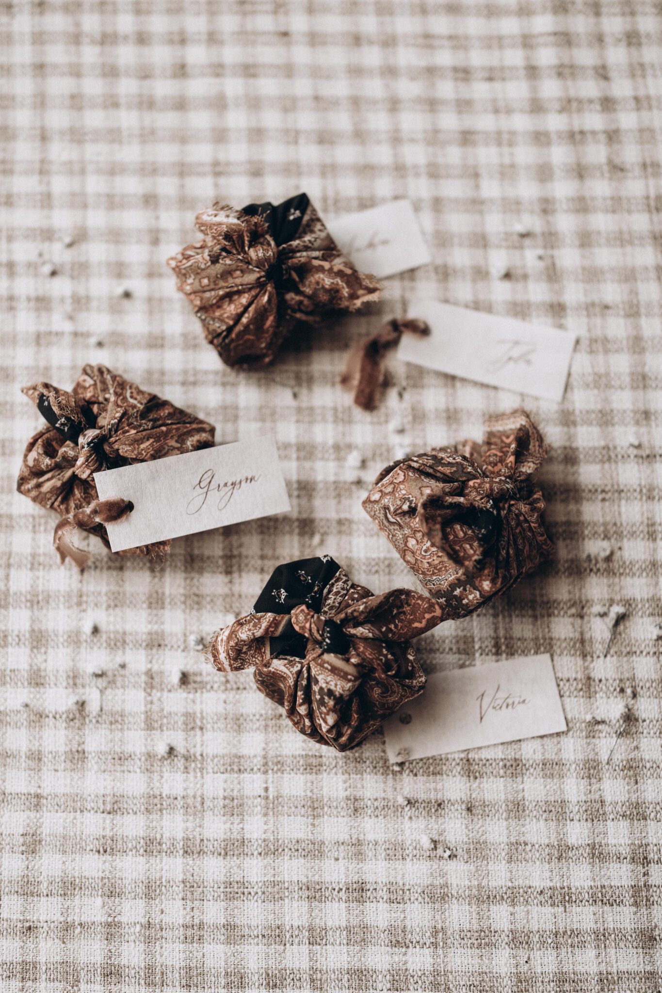 Custom wedding favours wrapped in country chic patterned linen, with handwritten name cards, at Countryside Barn, in Lethbridge, Alberta. 