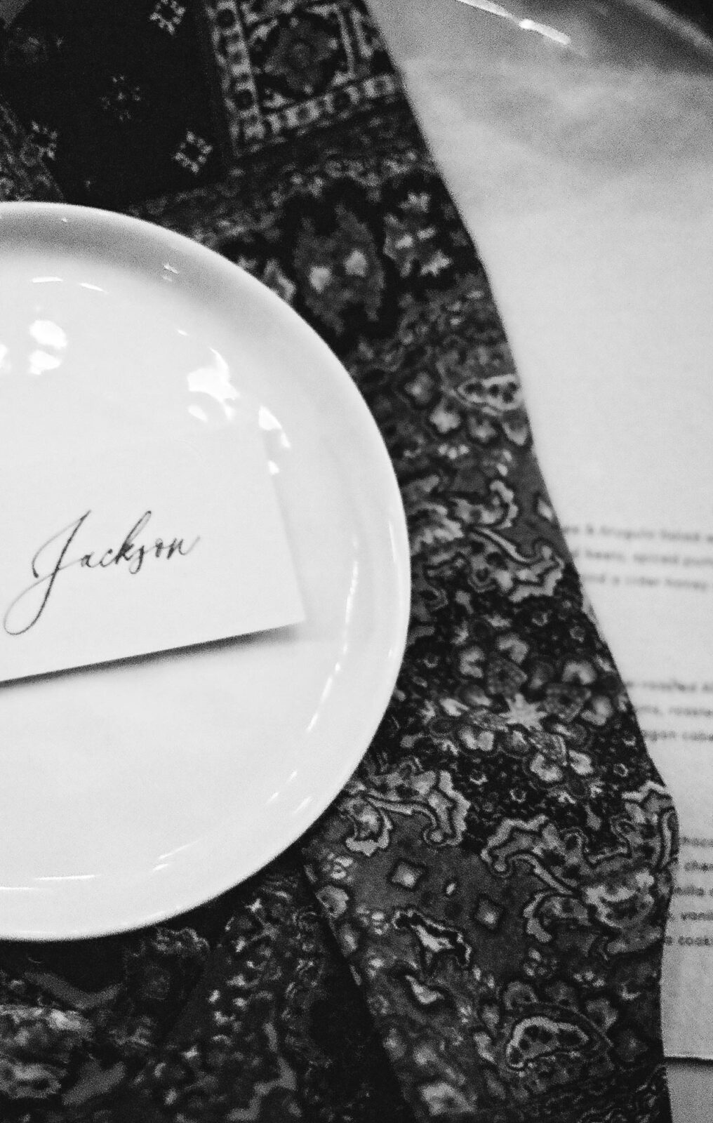 Black and white photo of country chic tablescape, hand-written name cards, film photography style. 