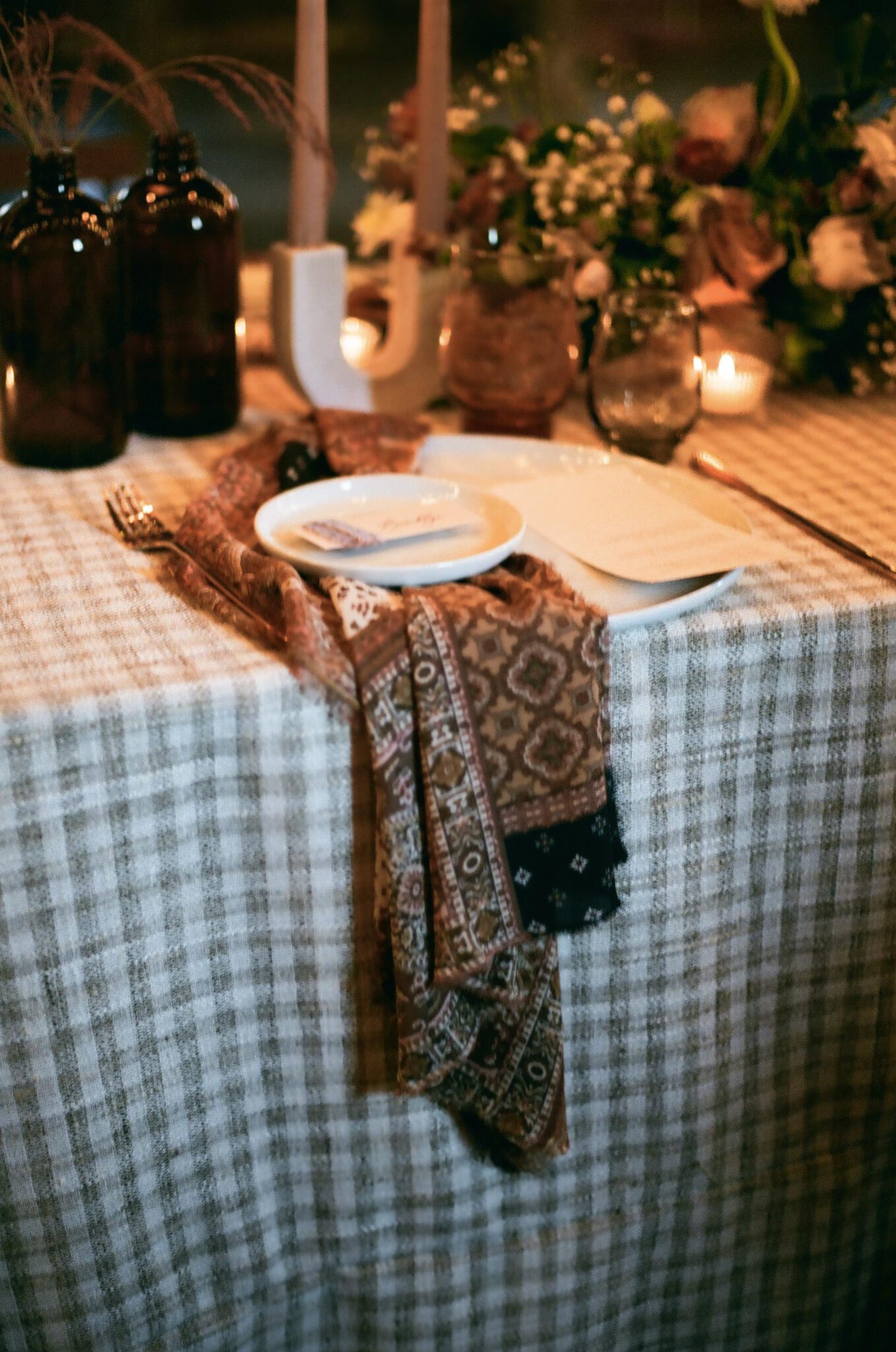 Country chic tablescape with patterned linen at wedding in Lethbridge, Alberta, moody candle-lit atmosphere.
