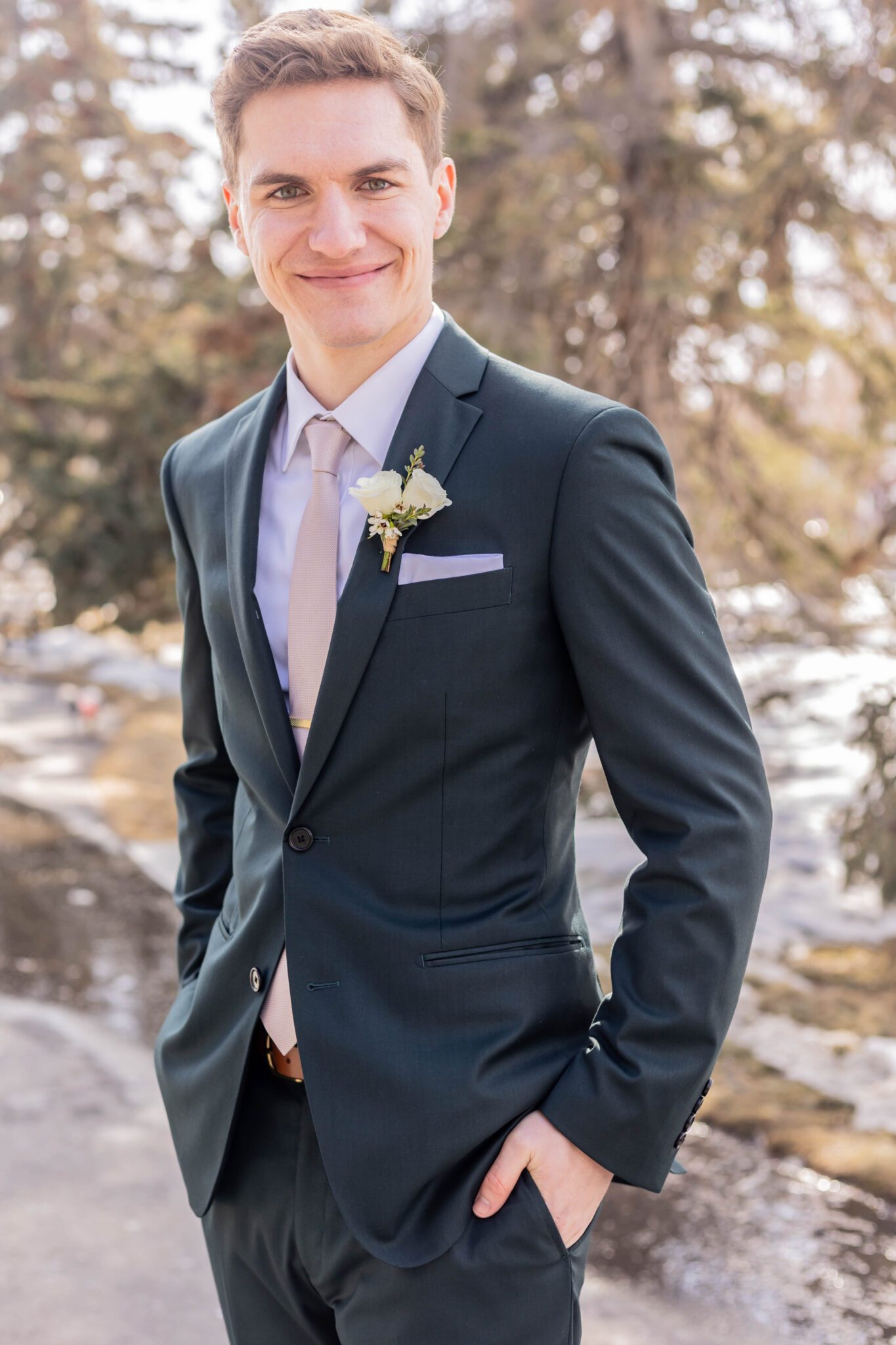 Portrait of groom on his wedding day at the Inn on Officer's Garden, wearing a navy blue suit, complimented by a light pink tie. 