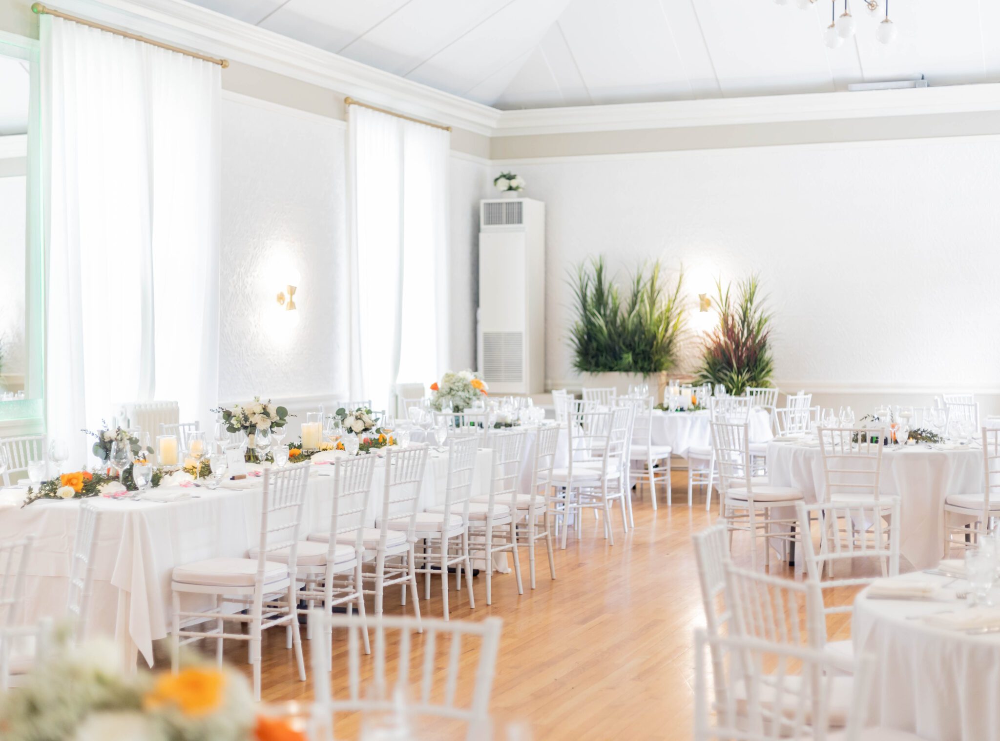 Bright, classic Calgary wedding reception room with elegant white florals, infused with vibrant orange. Classic Calgary Wedding with Bright Colours & Bathtub Portraits.