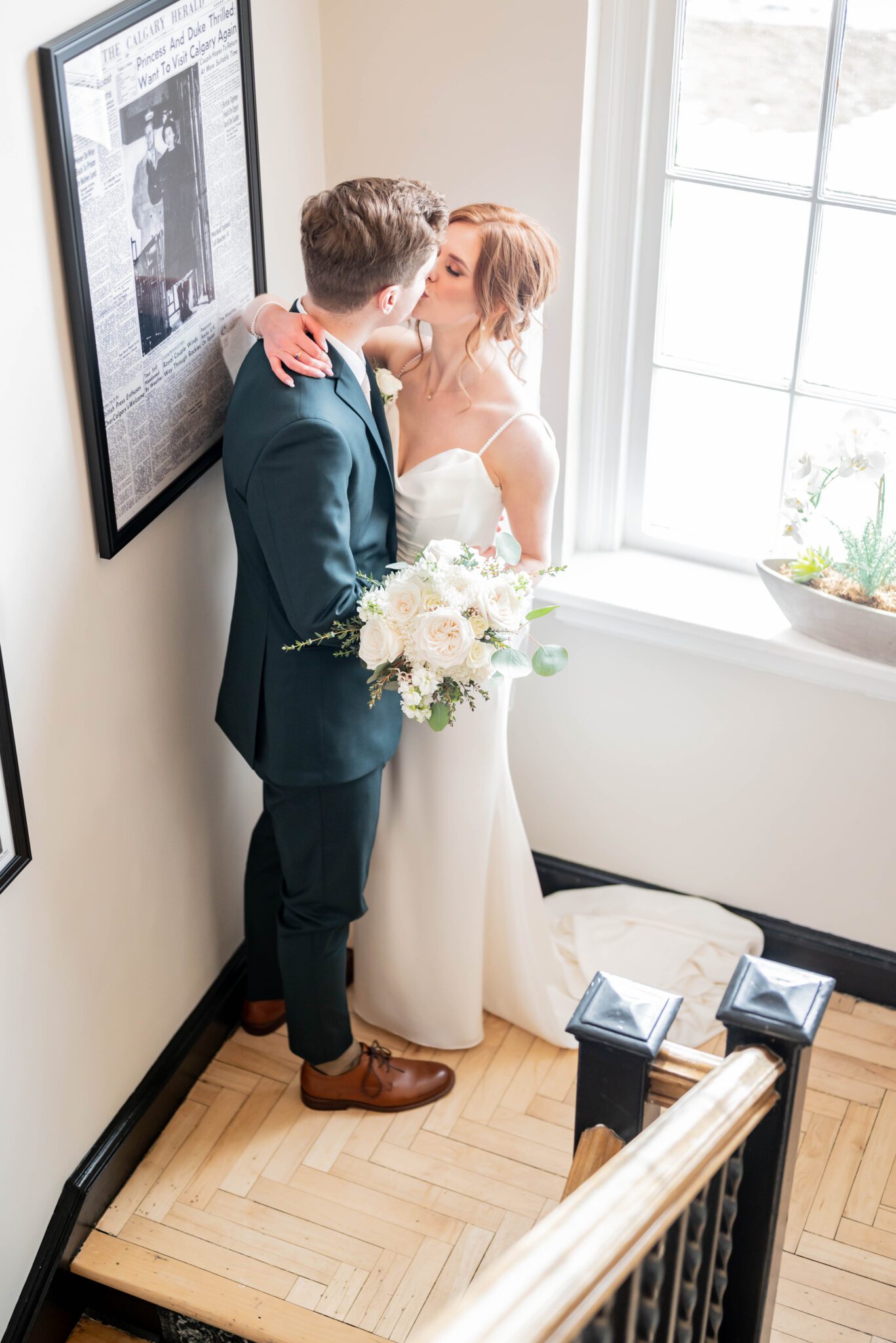 Bride and groom share a kiss in stairwell at the Inn on Officer's Garden wedding venue, bridal portrait inspiration, classic Calgary wedding inspiration. 