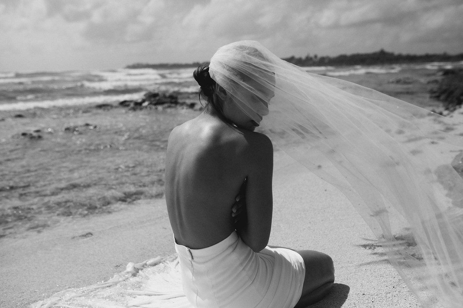 Black and white bridal portrait in Mexico on the sandy shores, with veil blowing in the wind, Storm-inspired bridal inspiration from Tempête with an effortless & free-spirited nature. 