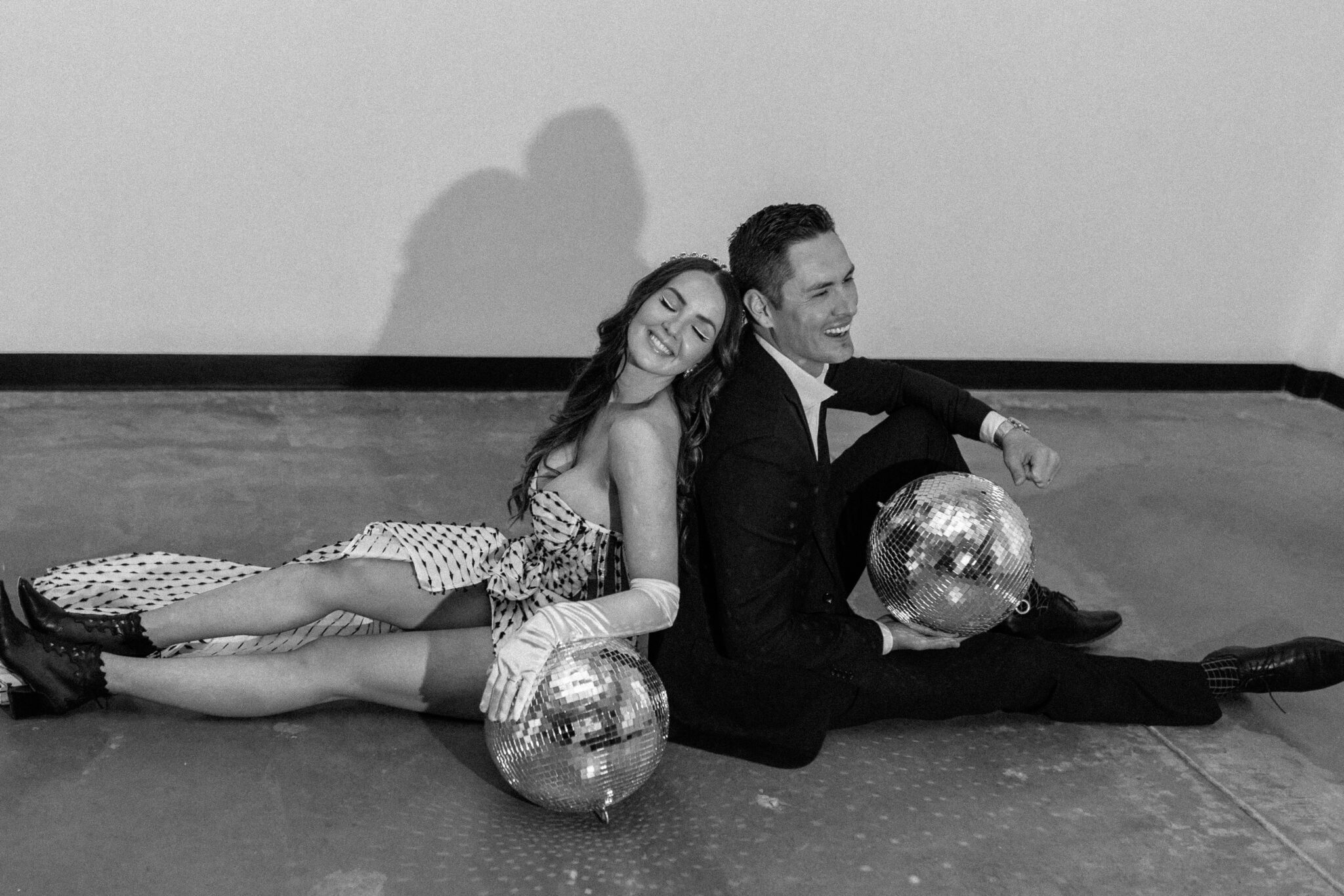 Bride and groom holding disco balls at retro-inspired wedding. 