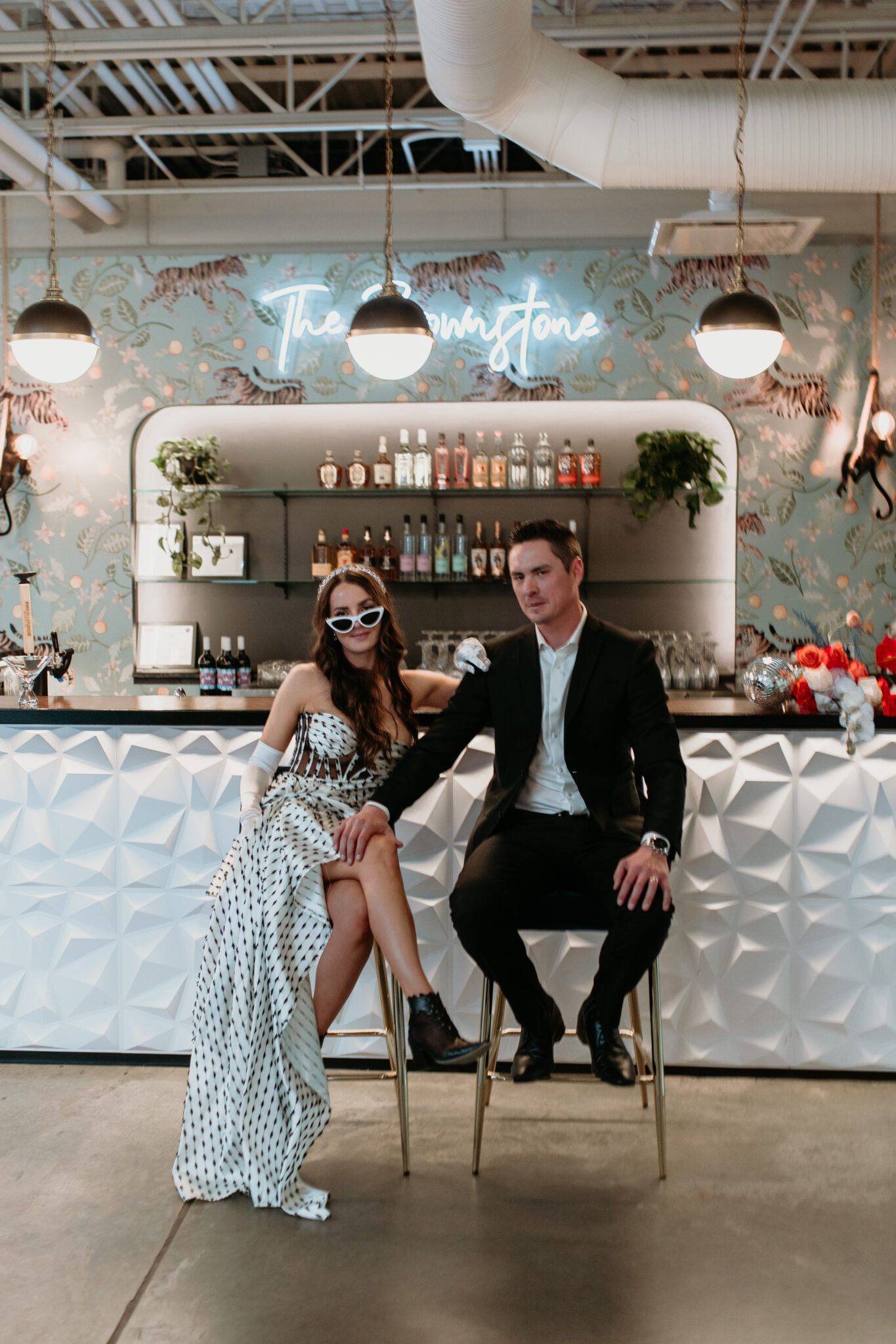 Chic and stylish bride groom sitting at bar of The Brownstone in Calgary, Alberta, during bold modern wedding with retro styles with eye-catching accents. Styled by Rebekah Bronte Designs.