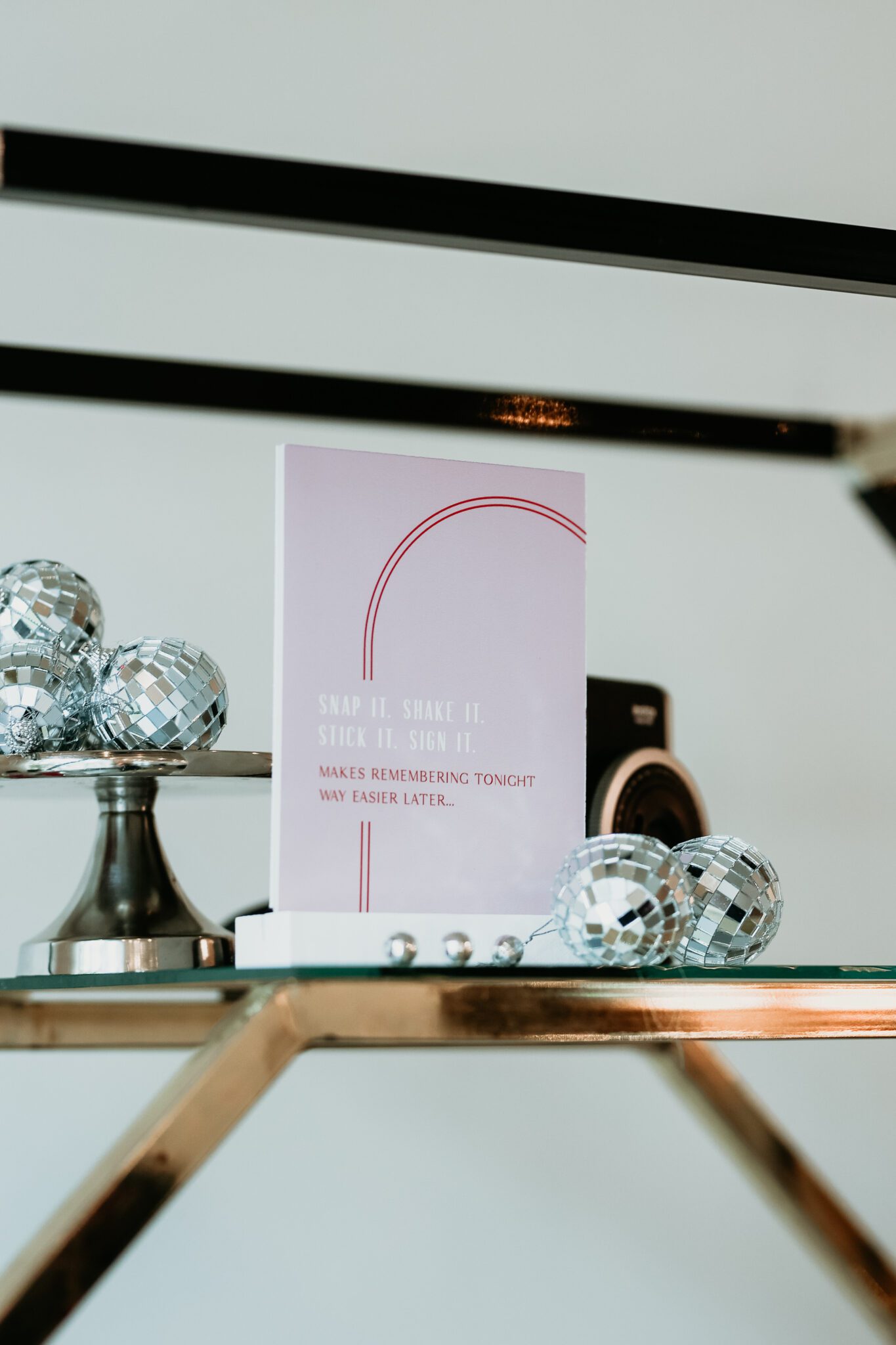 Chic wedding reception decor featuring a fusion of modern and retro aesthetics: modern decor elements alongside retro-inspired stationery and signage, styled with vintage cameras and mini disco balls, creating a dynamic visual contrast.