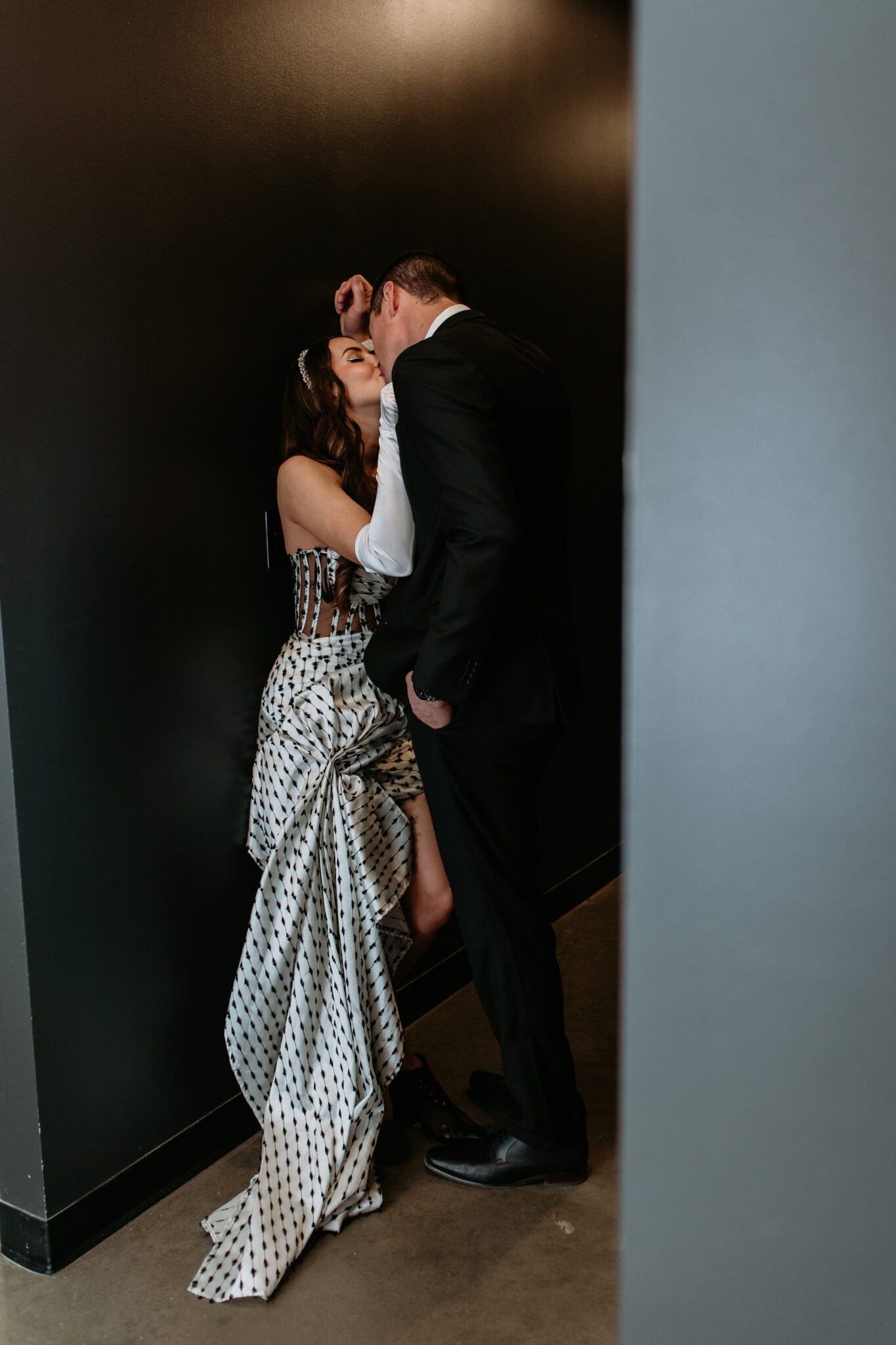 Bride and groom kissing in hallway at retro-inspired wedding at The Brownstone in Calgary, Alberta.